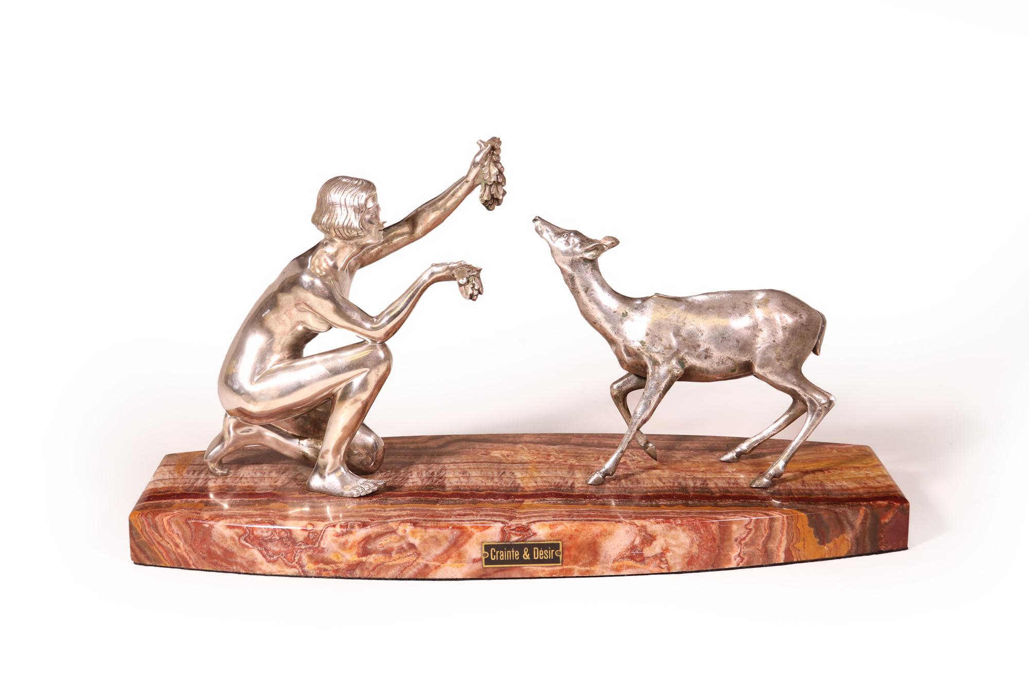 Une étonnante sculpture en bronze argenté d'une dame nourrissant un bébé cerf, produite en France par D,Arte, montée sur une superbe base en onyx rouge. Très bon état général, quelques traces d'usure de l'argent, créant une belle patine

Âge :