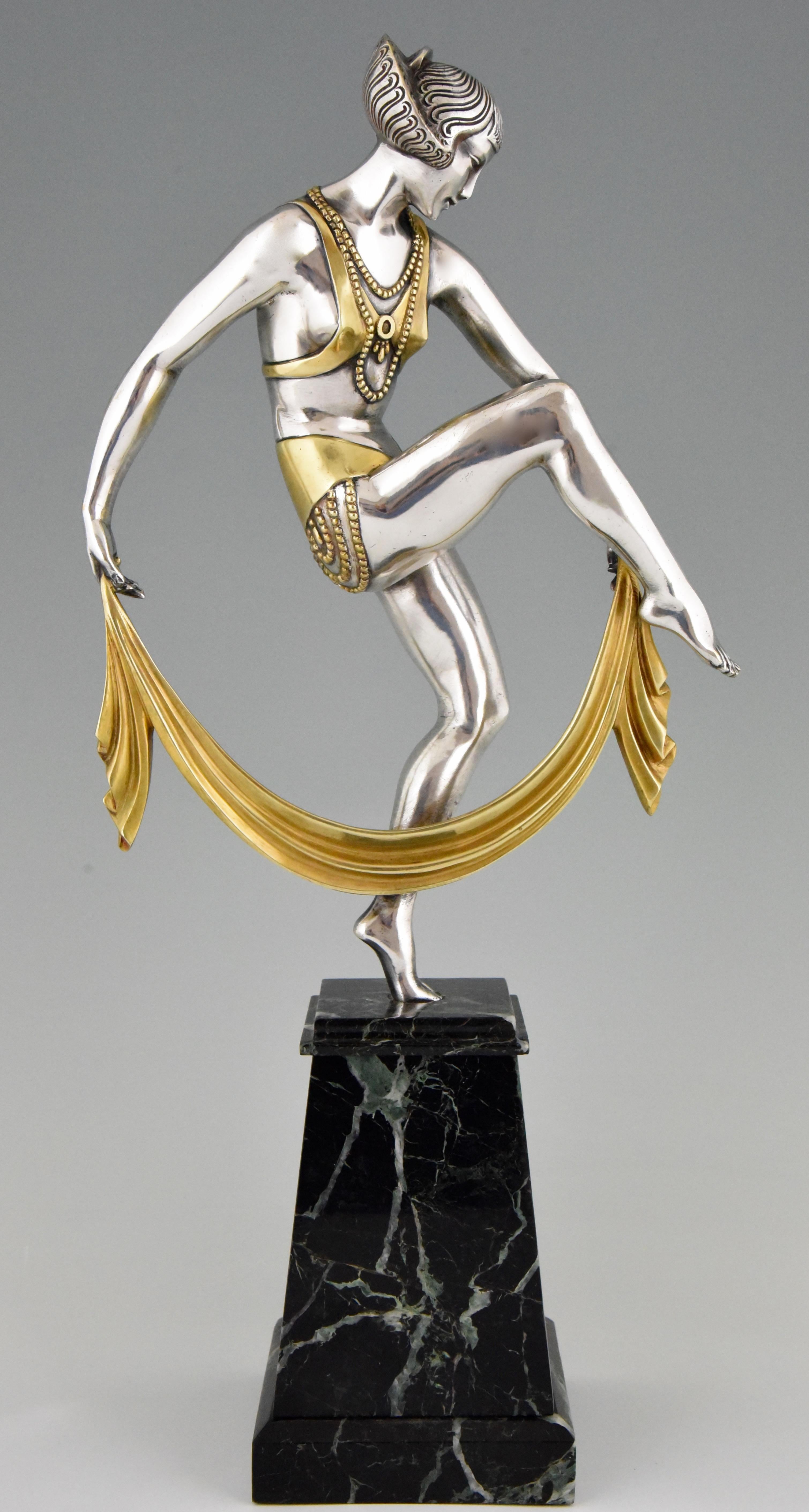 Elegant Art Deco bronze sculpture of a scarf dancer by Raymonde Guerbe.
The beautifully detailed silvered and gilt bronze figure stands on a fine green marble base. France 1925. This bronze is illustrated on page 282 of the book “Statuettes of the