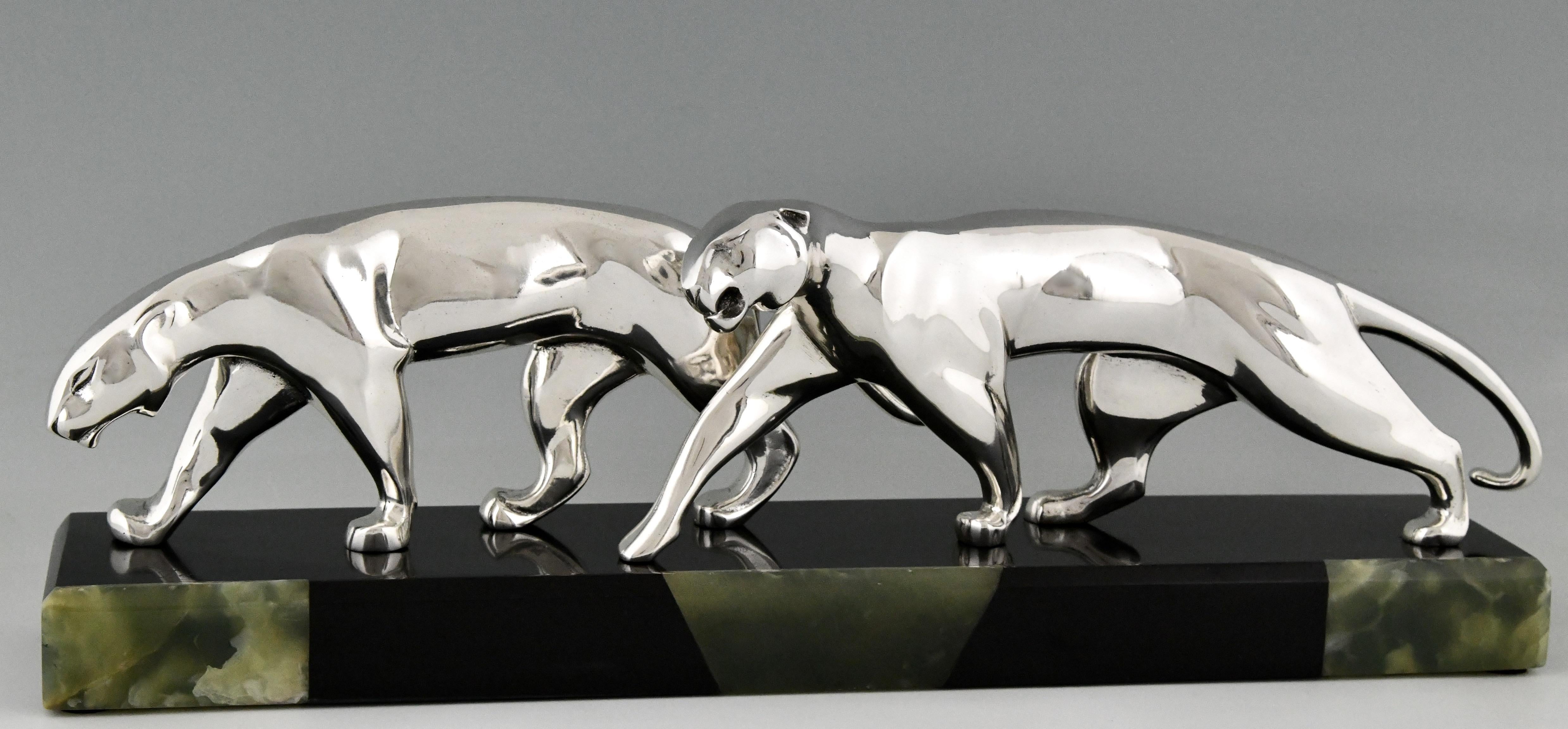 Art Deco silvered bronze sculpture two panthers by Michel Decoux, France 1837-1924. The panther sculptures are mounted on a Belgian Black marble base with onyx inlay. France ca. 1920.