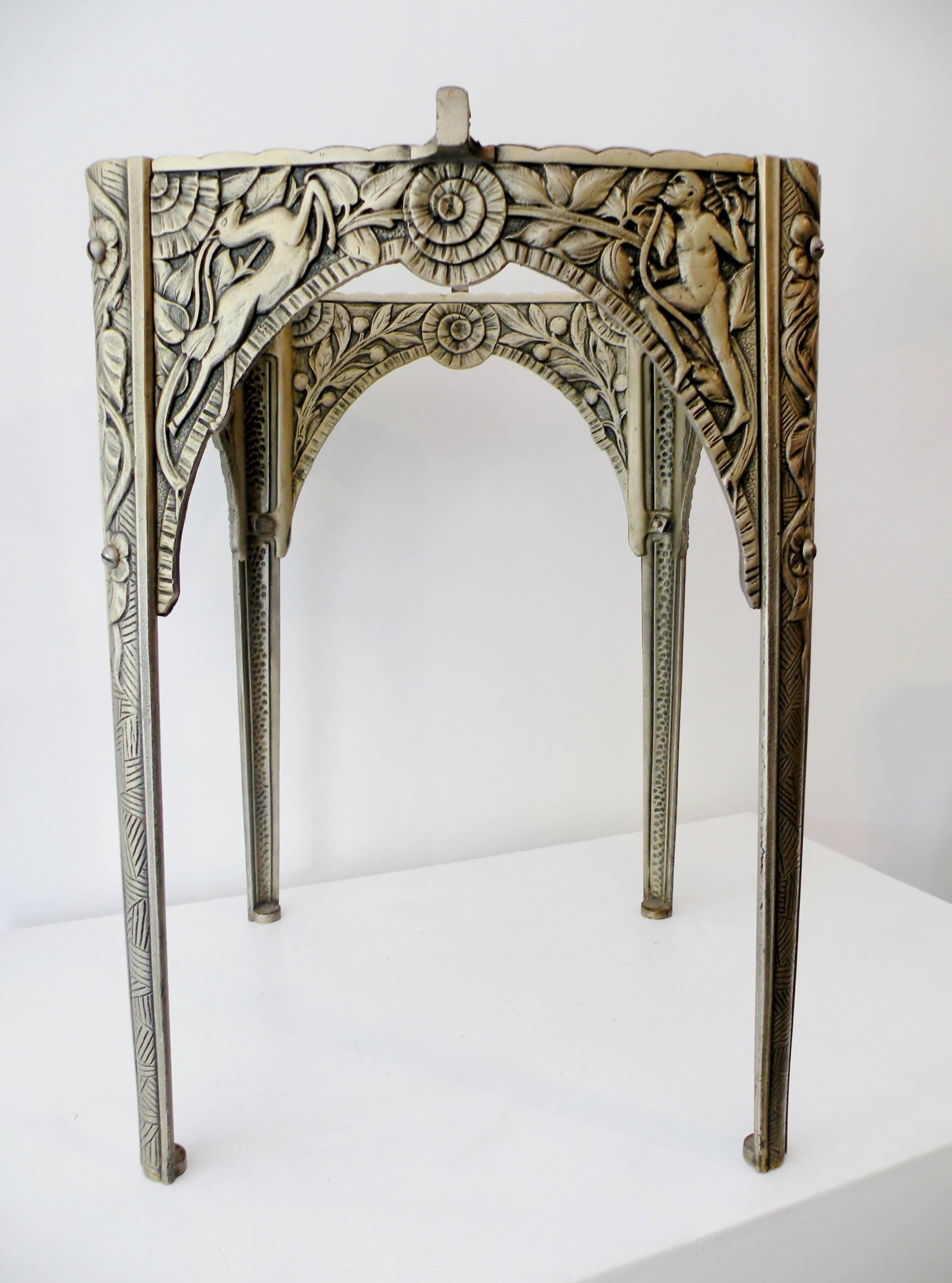 Finely detailed Art Deco cast iron cocktail accent table depicting scenes of Satyre and gazelle with folliage. Decoration extends to the interior as well. Silver and old clear lacquer surface finish. Unmarked and similar in design and manufacture to
