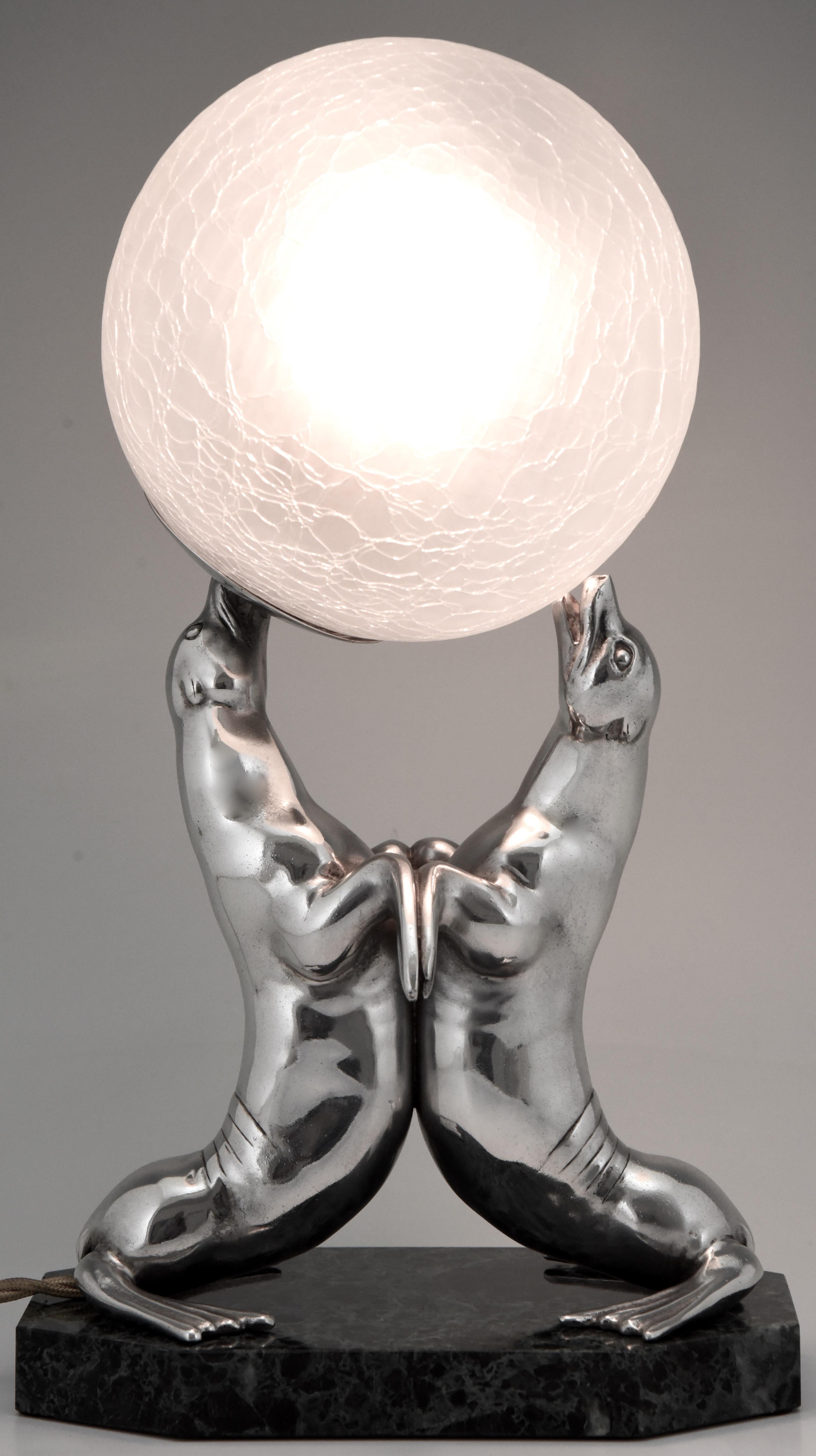 Lovely silvered Art Deco lamp of two seals playing with a ball by the French sculptor Louis Albert Carvin. The lamp stands on a green marble base and has a crackle glass shade. France, 1930. “Animals in bronze” by Christopher Payne. Antique