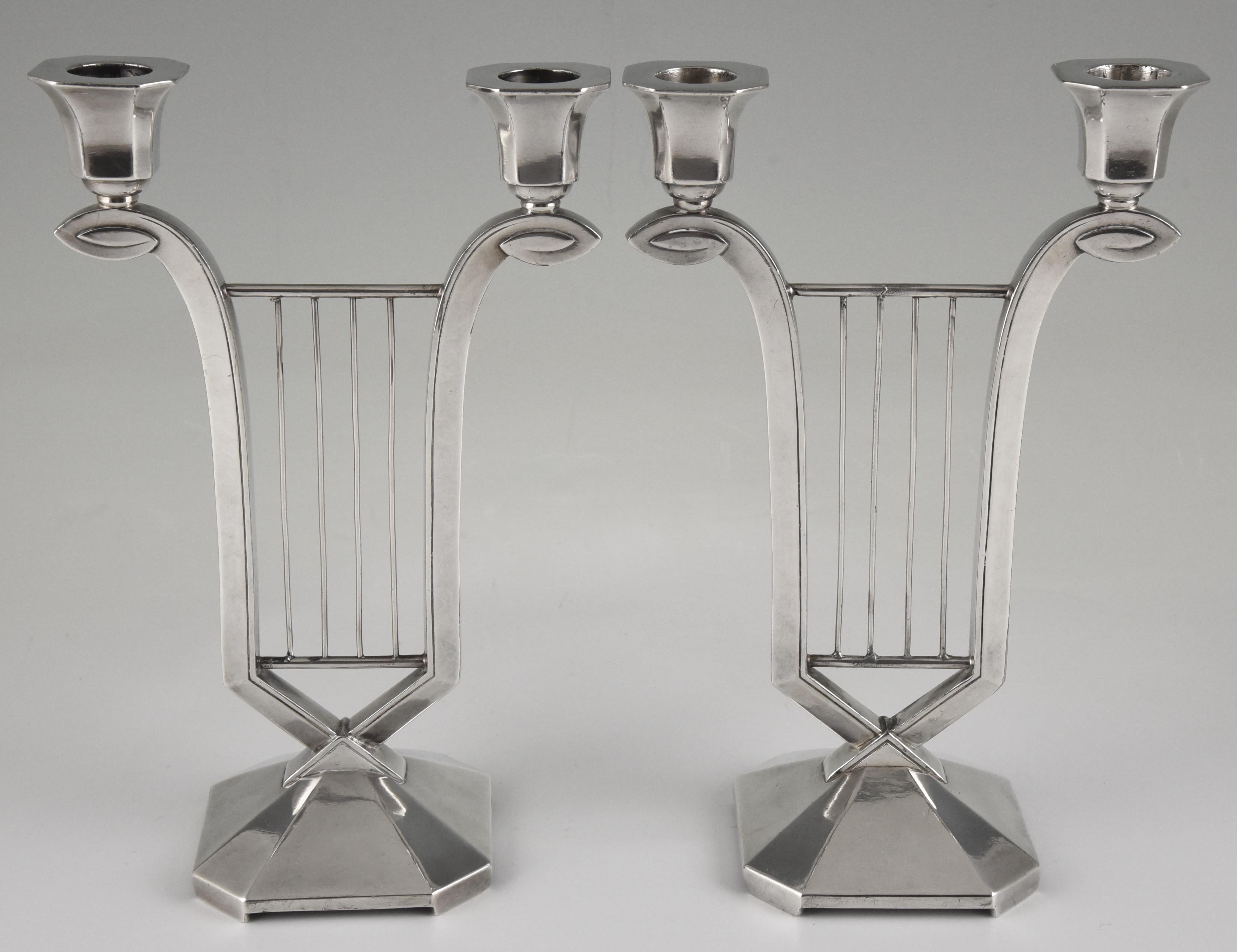 Beautiful pair of silver plated Art Deco two-light candleholders in the shape of a lyre by Gallia. In the manner of Sue et Mare. France 1930. 

About Gallia. ?“The Paris salons 1895-1914” by Alistair Duncan. Published by the Antique Collectors