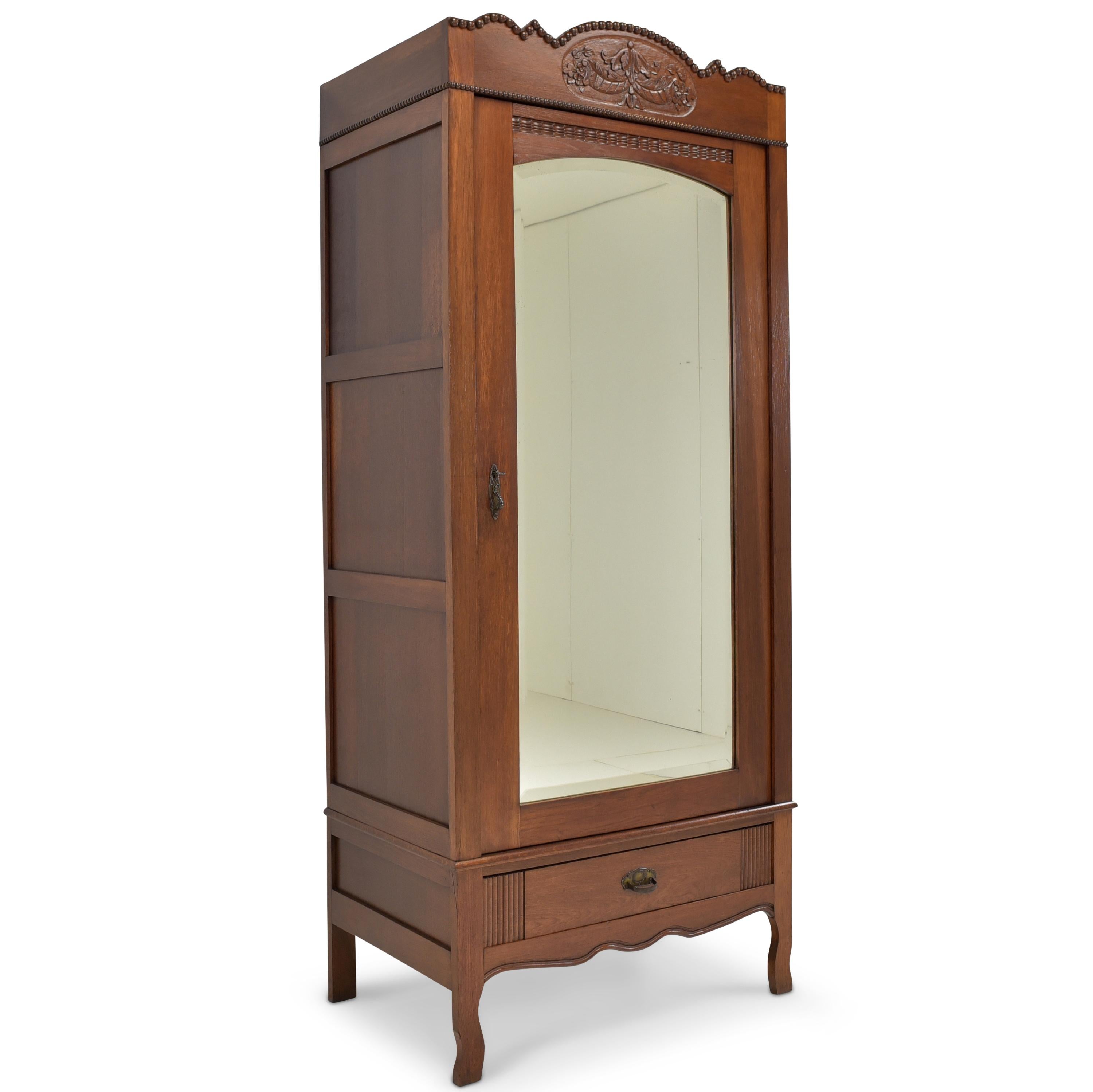 One-door wardrobe restored Art Deco oak floorboard narrow

Features:
Oak, mostly solid
Single-door model with mirror, drawer and five shelves
Solid softwood shelves, height adjustable
Drawer pronged
Original faceted mirror
Beautiful carved