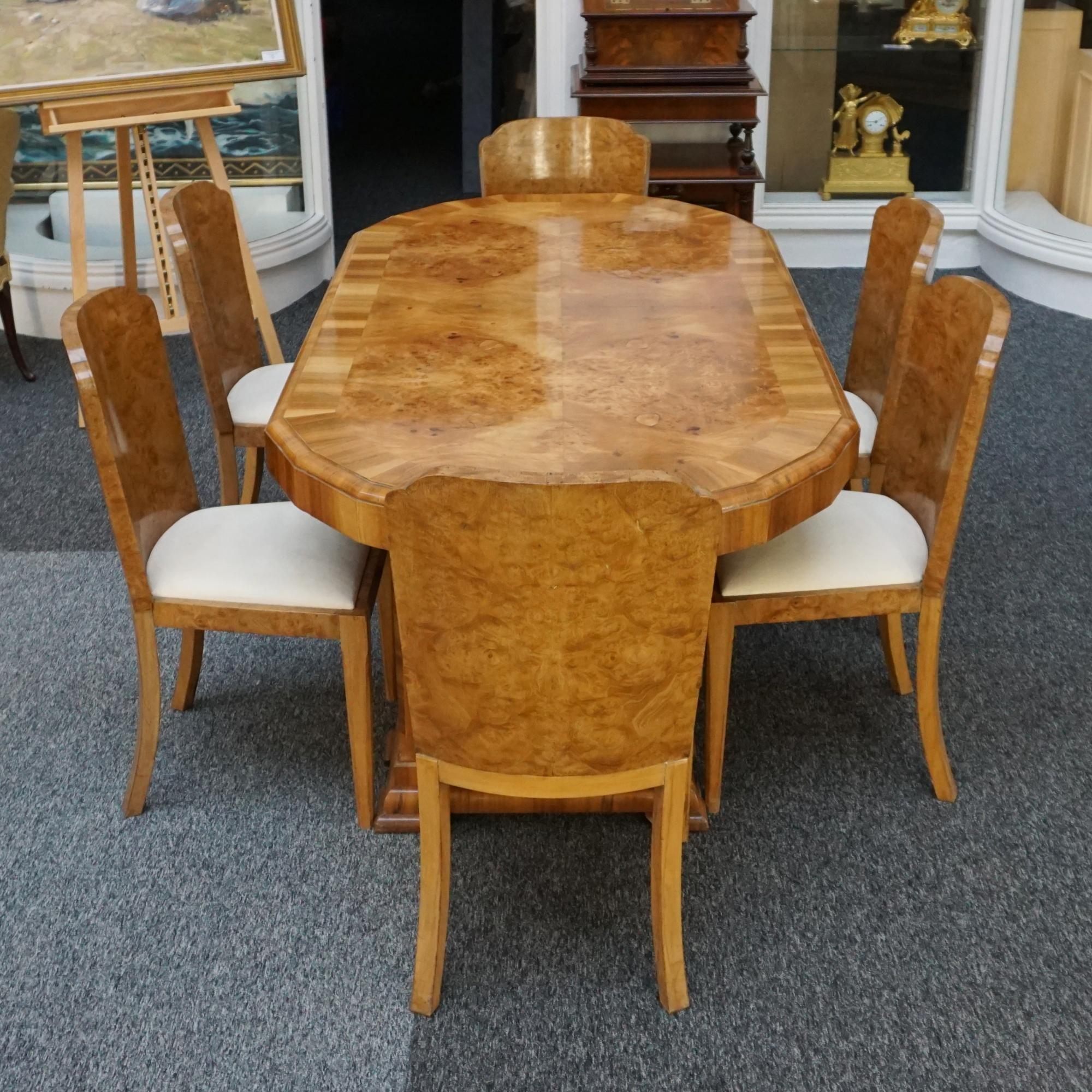 An Art Deco six seater dining suite. Burr walnut and figured walnut veneered dining table with six burr walnut veneered dining chairs. Faux suede upholstery. 

Dimensions: H 76cm W 97cm L 190cm Chair H 90.5cm W 44cm D 42cm Seat H 45cm

All of our
