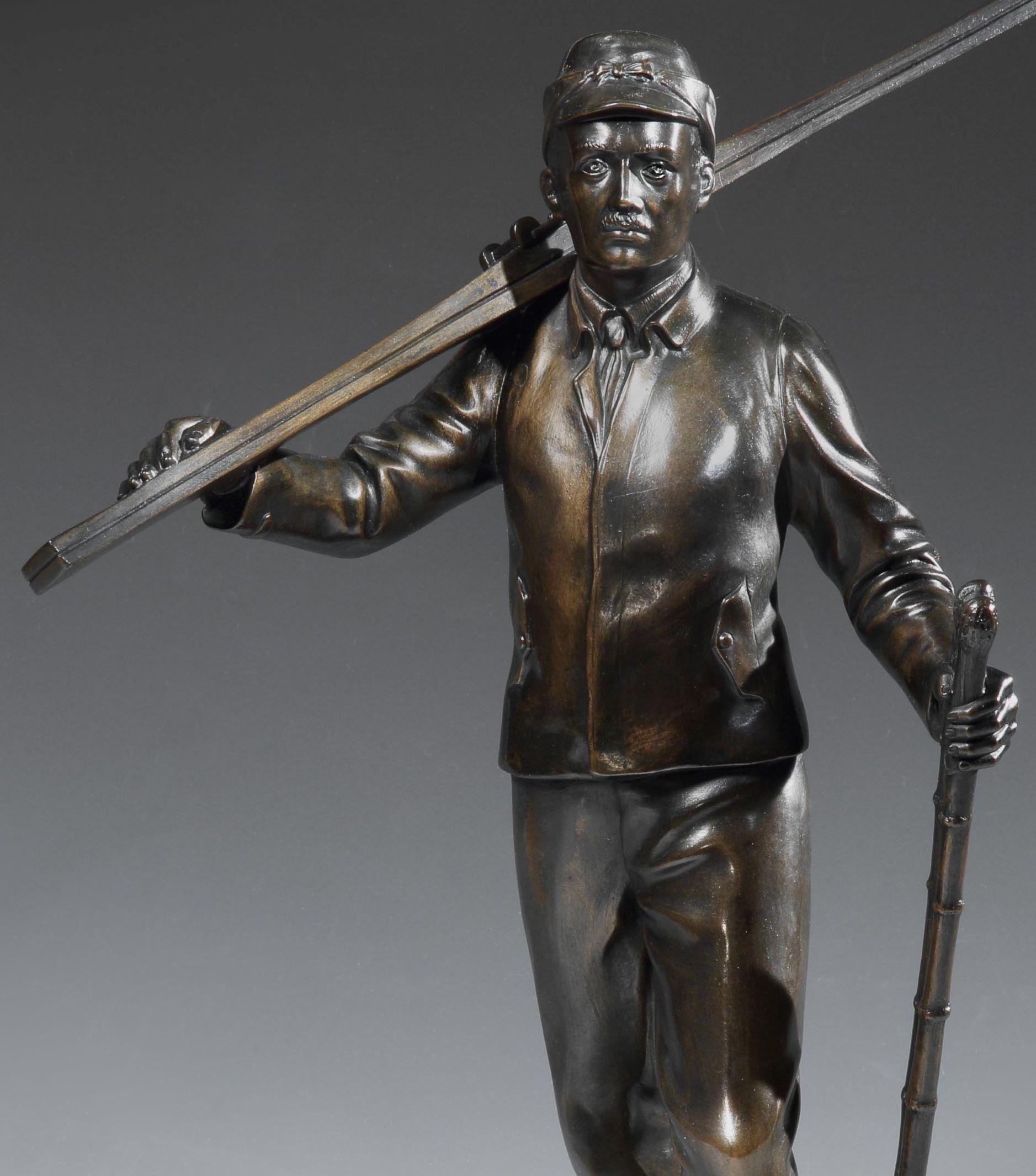 A strong figurative ski bronze in the German School style, of a male skier walking through the snow with his skis over his shoulder and sticks in his hand. The warmly patinated figure stands on a deep, tapering bronze sôcle signed H.S. MÜNCHEN and