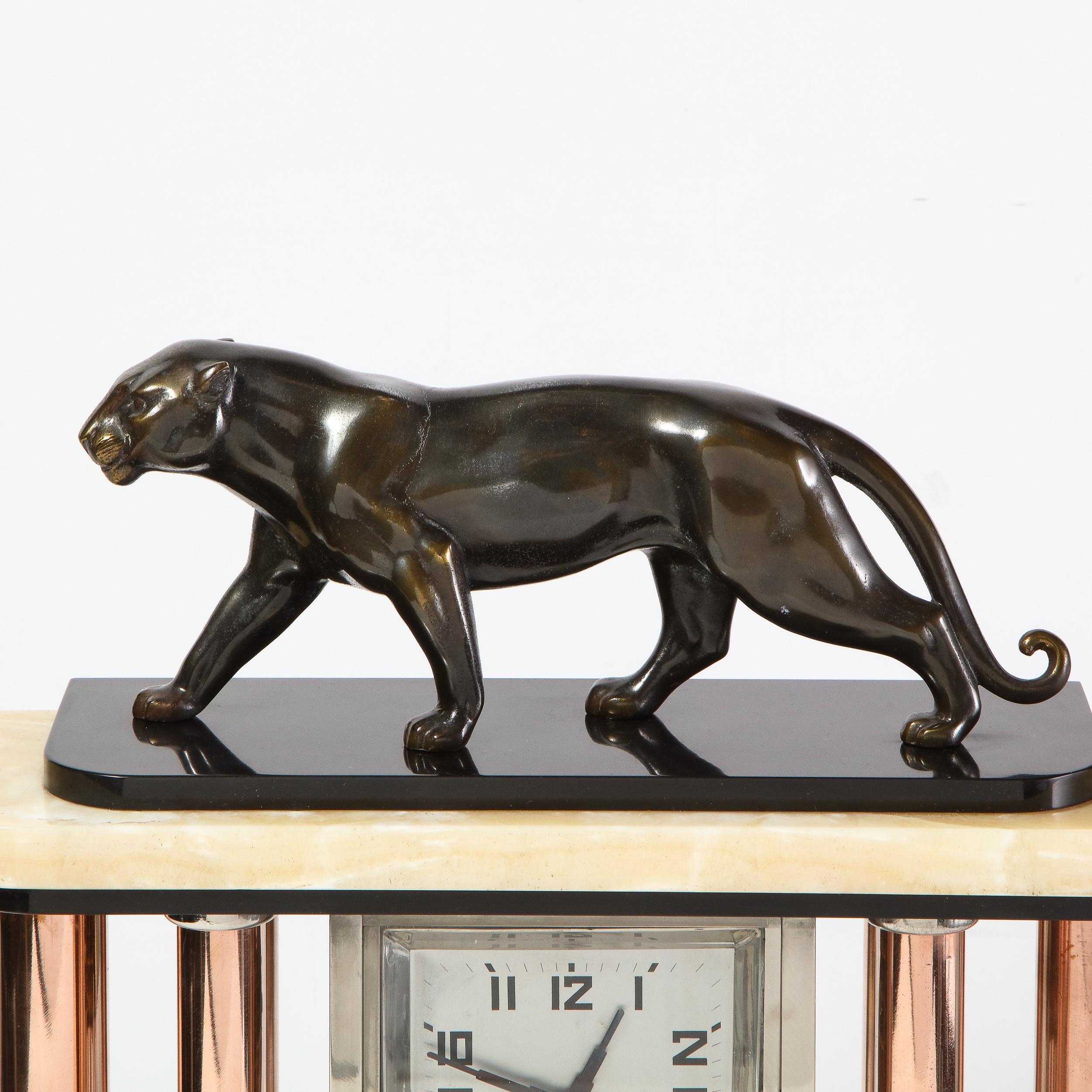 This elegant Art Deco mantel clock was realized in the United States, circa 1930. It features an alabaster base with streamlined sides that connects to a skyscraper style top in alabaster and bronze with a beautifully articulated stylized panther in