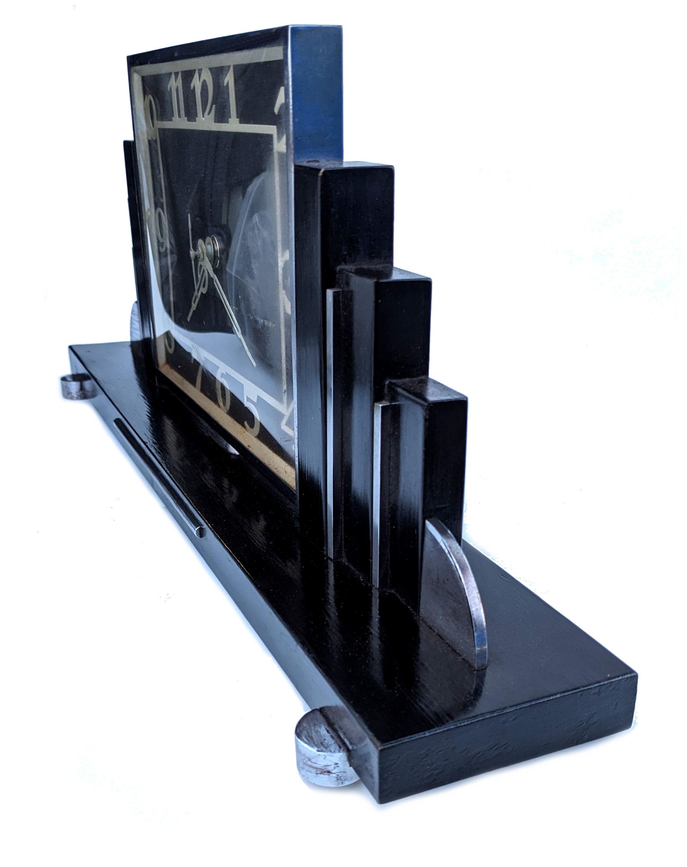 For your consideration is this very stylish 1930s Art Deco mantle clock made in England. Superb skyscraper stepped sides . Made from ebonized wood with chrome accents really sets this clock off perfectly. The movement which was originally electric