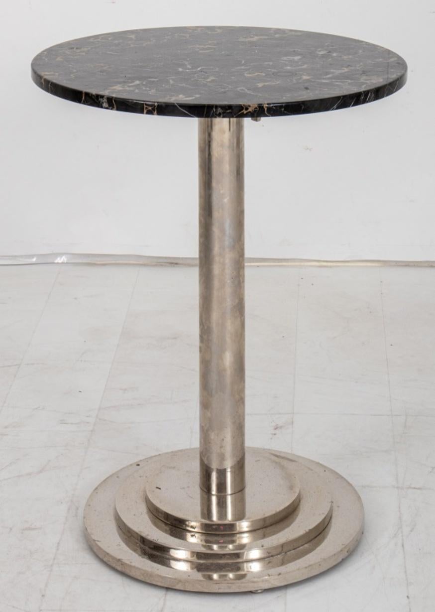 Art Deco period breakfast table, the chrome metal base with tiered skyscraper design and surmounted by a round Portoro marble top, in the manner of Donald Deskey (American, 1894-1989).

Dimensions: 30.5