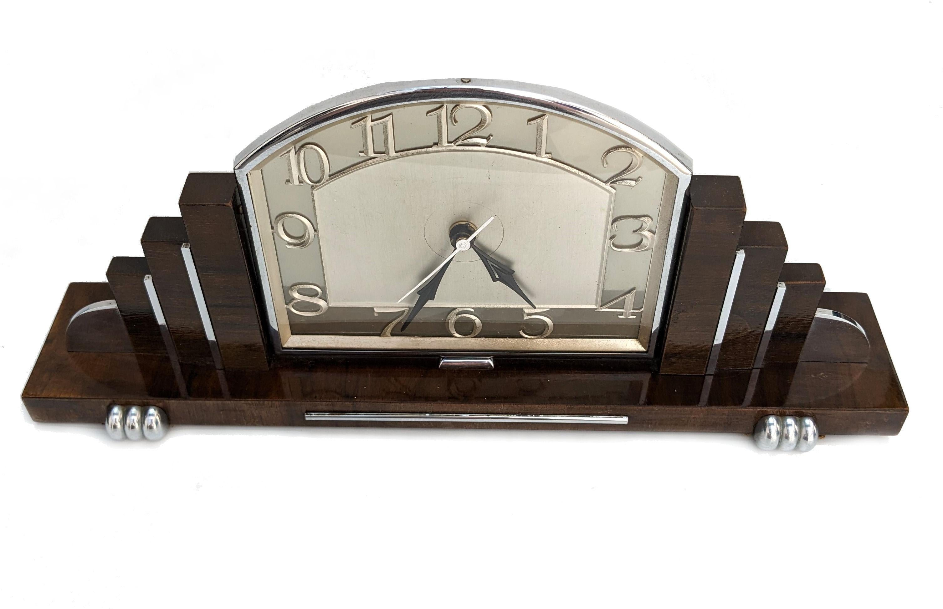 For your consideration is this very stylish 1930s Art Deco mantle clock made in England. Superb skyscraper stepped sides . Made from Walnut with chrome accents really sets this clock off perfectly. The movement which was originally electric which
