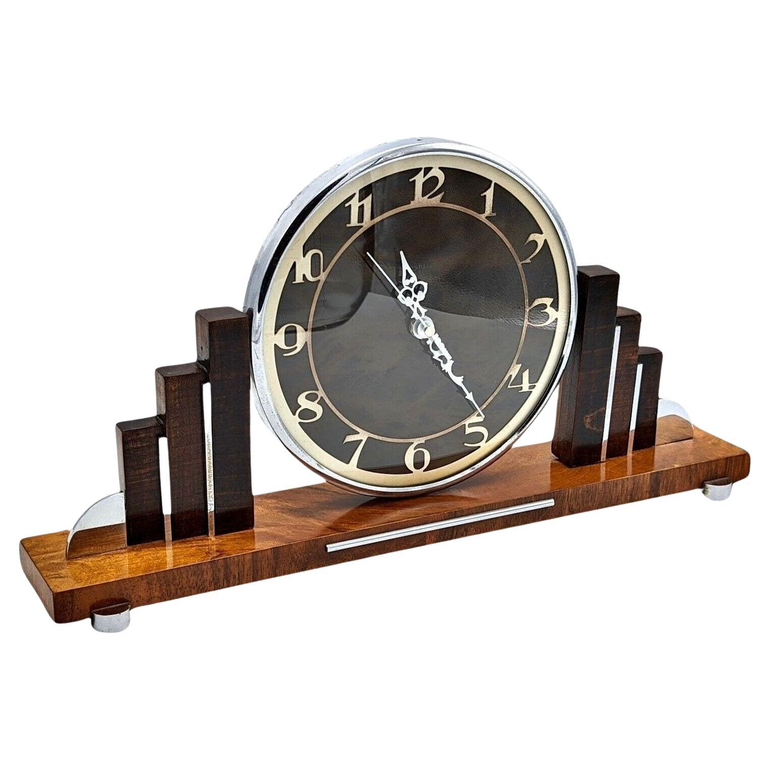 For your consideration is this very stylish 1930s Art Deco mantle clock made in England. Superb skyscraper stepped sides . Made from Walnut with chrome accents really sets this clock off perfectly. The movement which was originally electric which