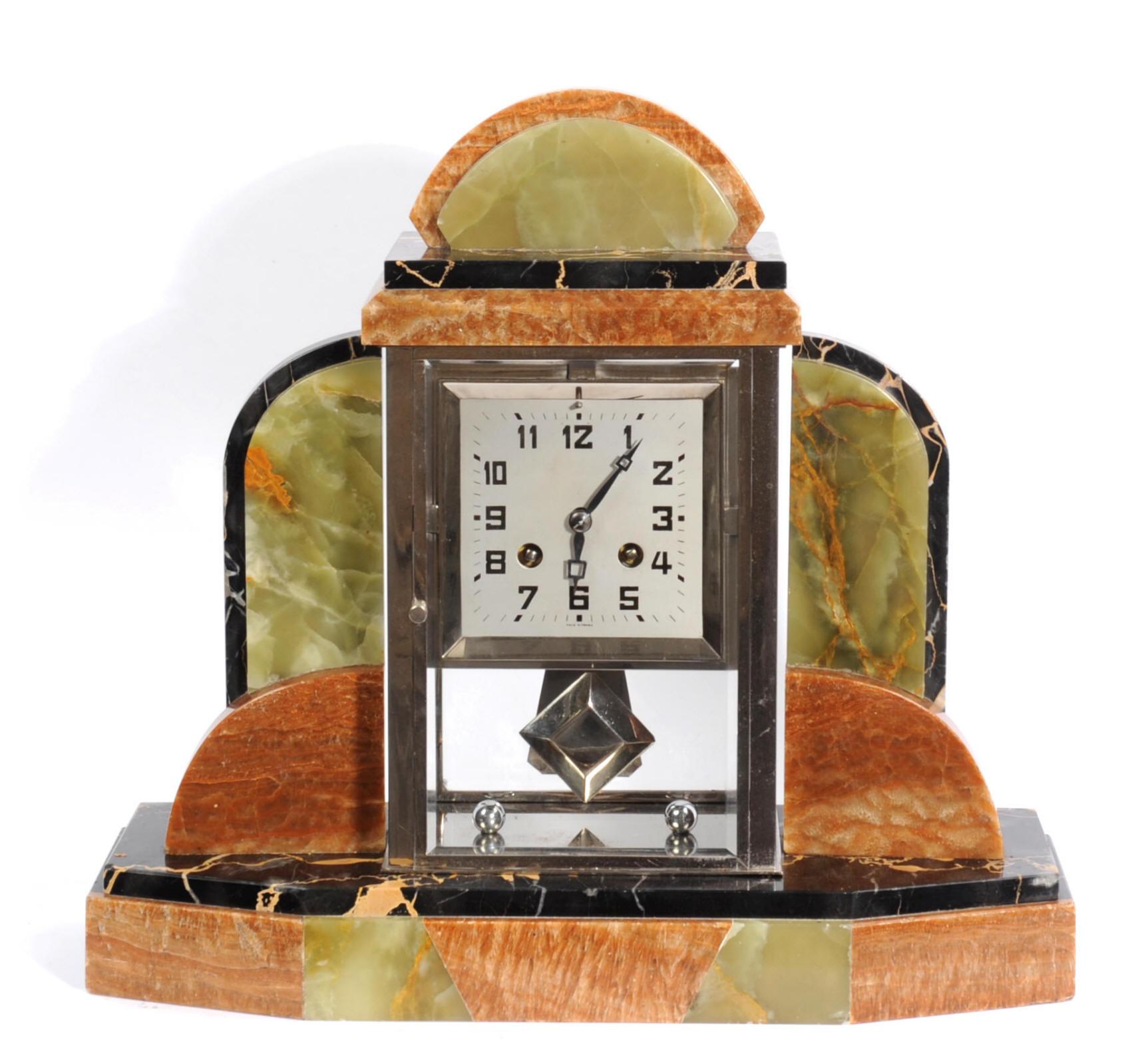 An elegant Art Deco clock of geometric 'skyscraper' design in beautiful specimen Portoro marble, black with gold veins, and accented with green and brown onyx. The top quality Paris movement is housed in a chrome plated bronze frame, glazed with