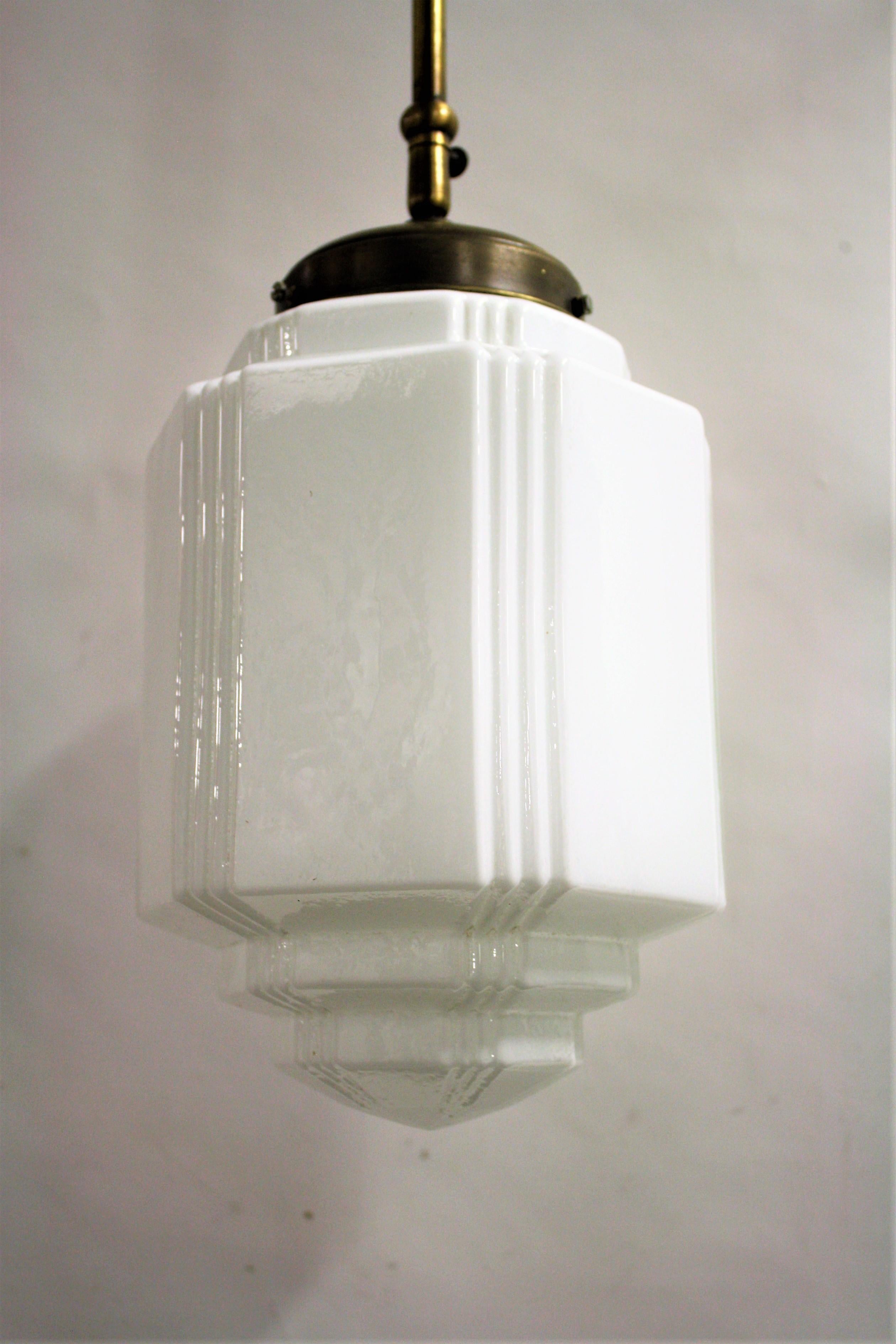 Opaline Art Deco 'skyscraper' hallway pendant light.

This skyscraper design lamp is very typical for the Art Deco era and was widely used to be hung in hallways, offices or larger public places.

The lamp has a copper ceiling cap and shade