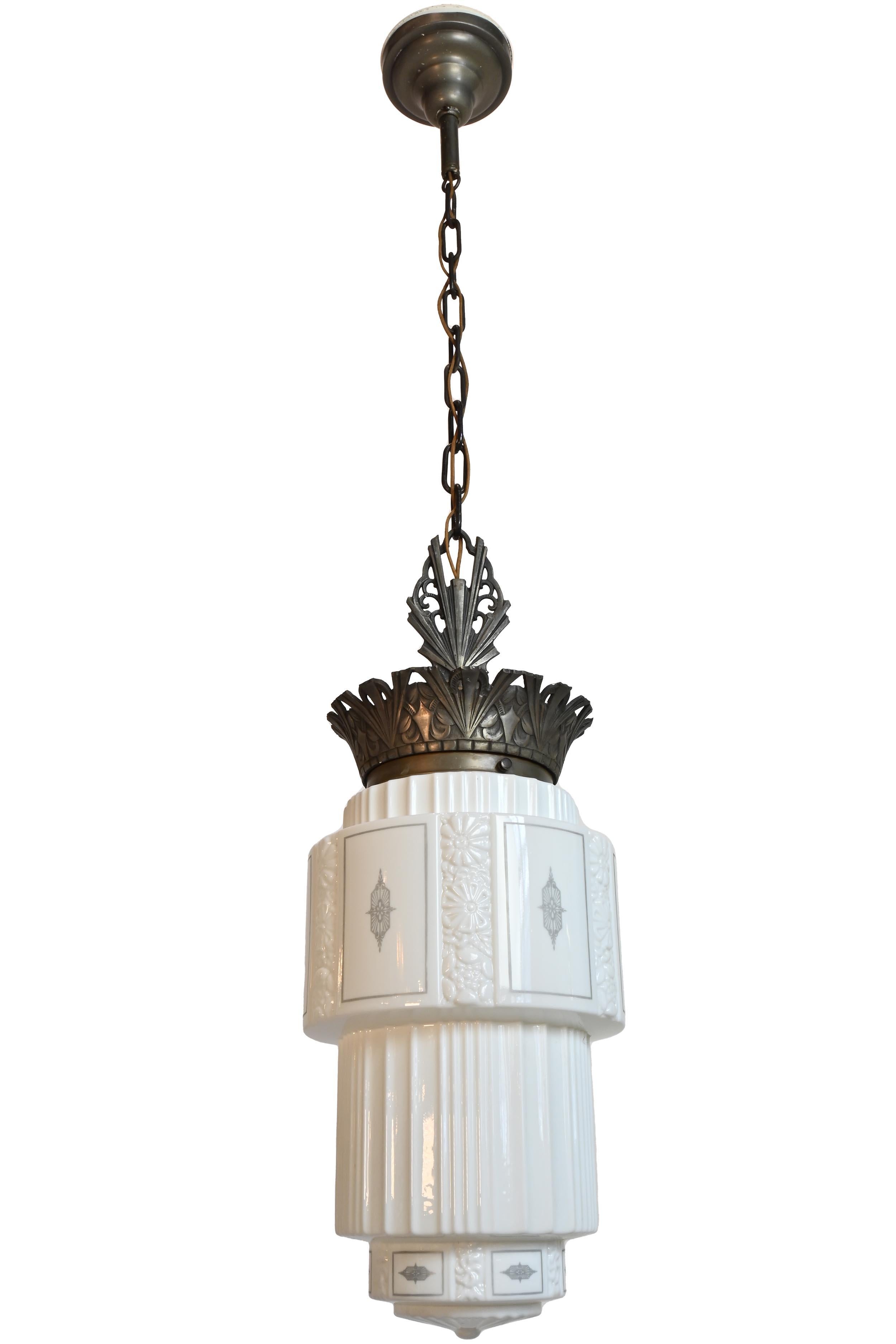 9 Available!

These finely crafted pendants feature an Art Deco design and grey stenciled details on their molded white glass shade. A pleasing mix of sharp lines and soft curved crown adorn their finished metal frames. A skyscraper design that is