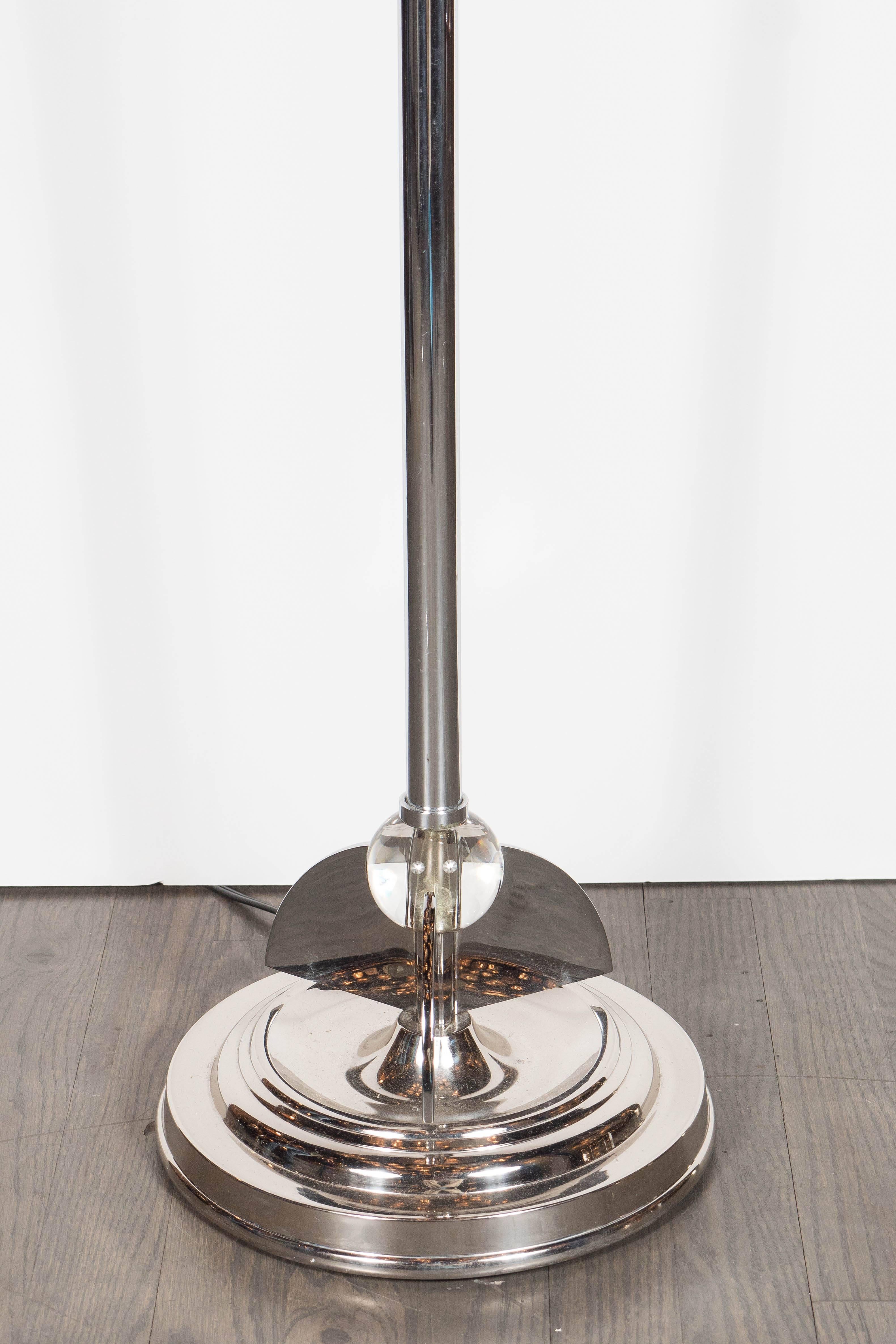 This stunning Machine Age Art Deco chrome floor lamp was realized in the United States, circa 1935. It features a chrome height adjustable design with skyscraper style and glass ball detailing. The adjustable original lampshade comprises of tiles of
