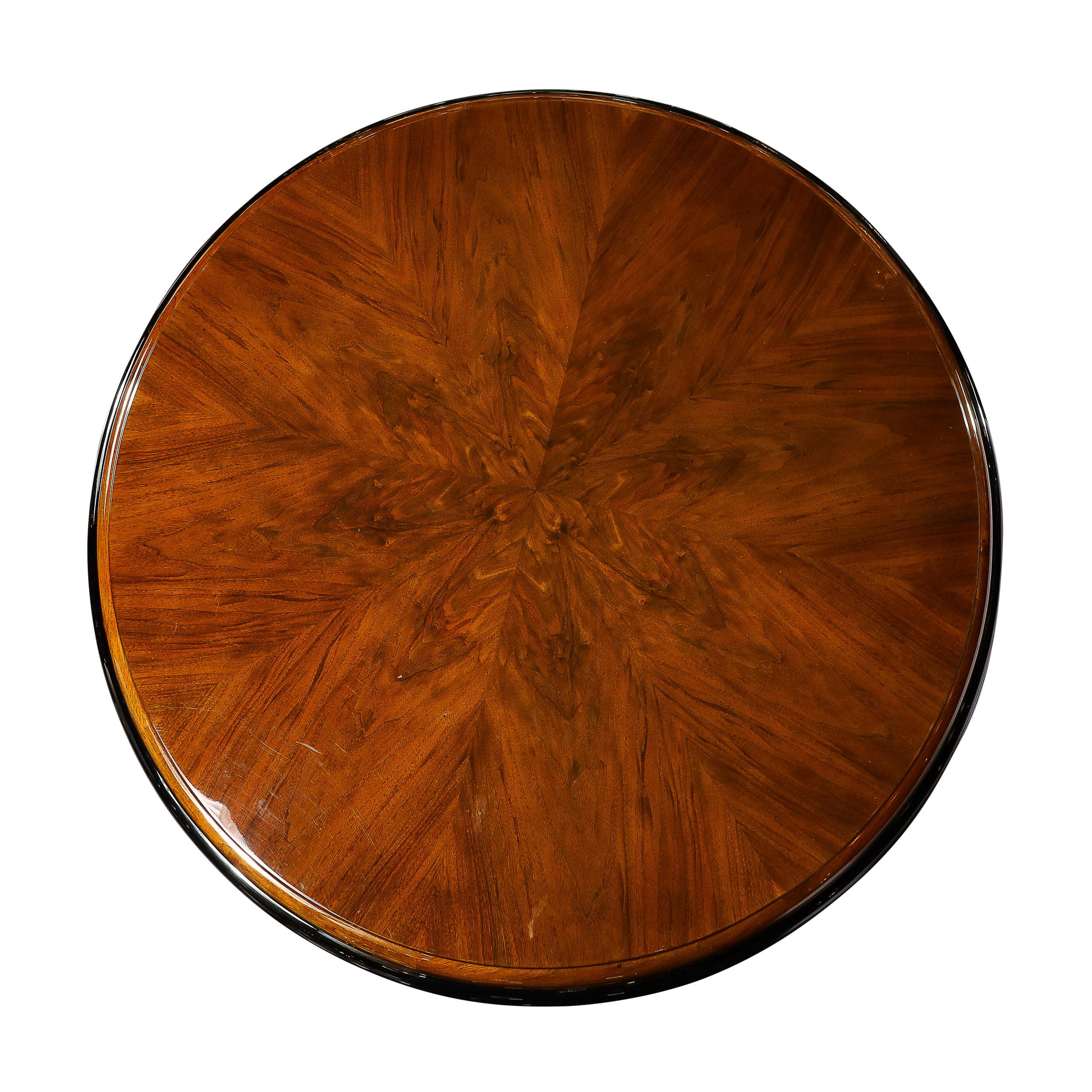 This refined Art Deco dining/centre table was realized in France, circa 1935. It features a three-tier black lacquer banded skyscraper style in bookmatched walnut with streamlined supports (also circumscribed in black lacquer) and undulating