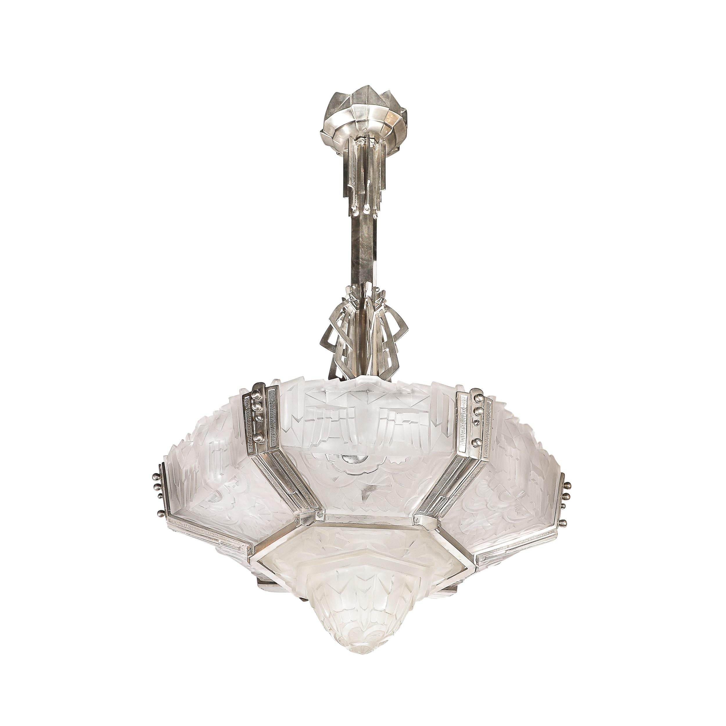 This rare and special Art Deco chandelier features six frosted relief glass panels with a center coupe all in a highly stylized Cubist geometric and floral motif ,all signed Hugue .The glass panels are fitted with a nickled bronze frame in a
