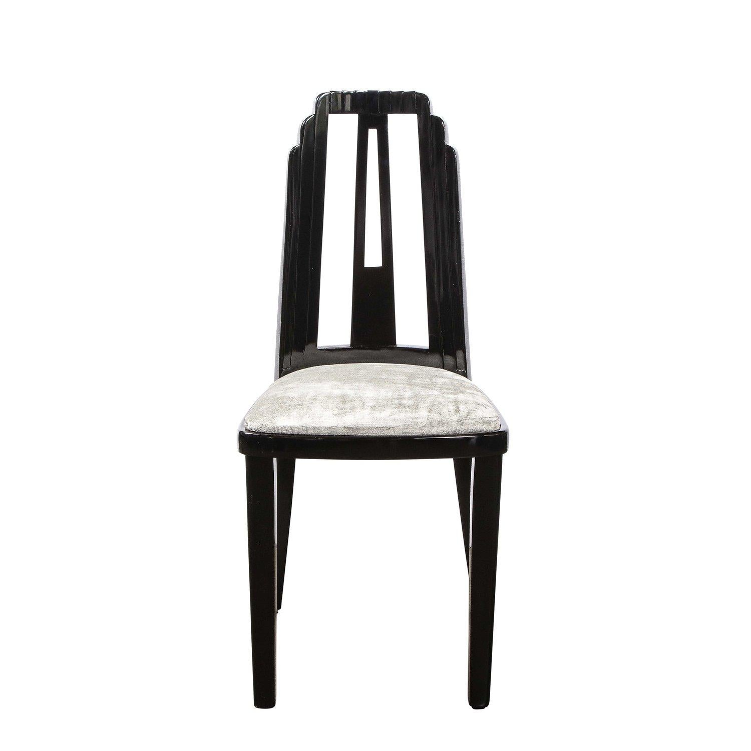 Questa bellissima sedia da pranzo Art Deco è stata realizzata negli Stati Uniti, intorno al 1930. Presenta uno schienale a grattacielo incanalato; gambe anteriori dritte e gambe posteriori in stile klismos dolcemente angolate; una stecca centrale