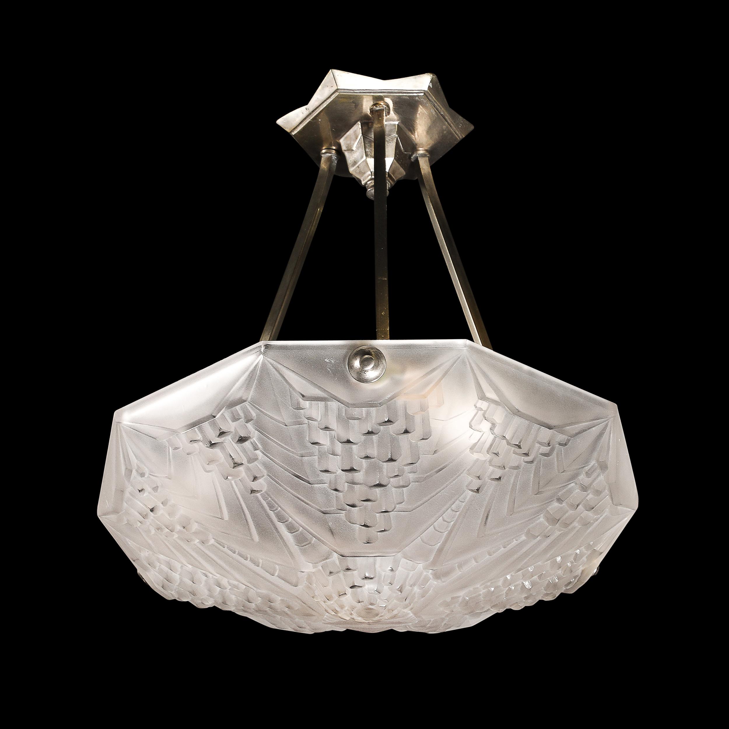 This refined Art Deco chandelier, designed by André Nuet for the esteemed French glassmaker Schneider, is a brilliant representation of 1930s craftsmanship and design. Composed of a single pressed glass shade with a frosted finish, the piece