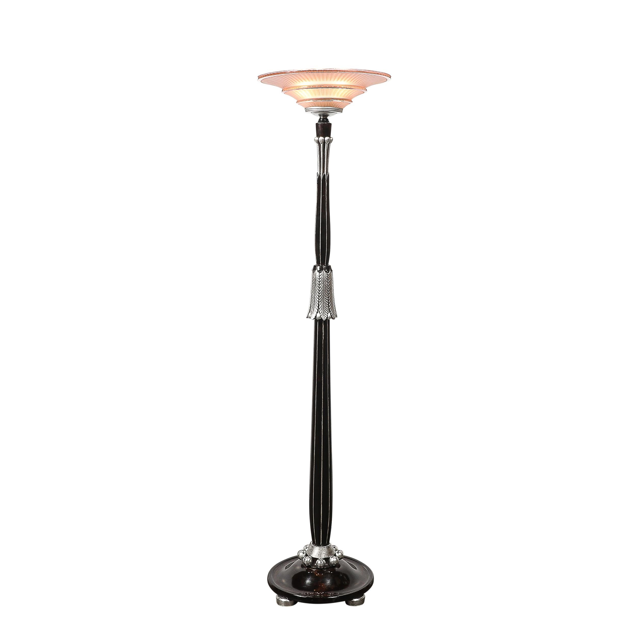 Esempio straordinario di design Art Déco francese, questa torciera incarna l'eleganza e l'estetica modernista dell'epoca. Realizzato in Francia nel 1935 circa, il pezzo è dotato di un paralume in vetro smerigliato color rosa, che diffonde la luce in