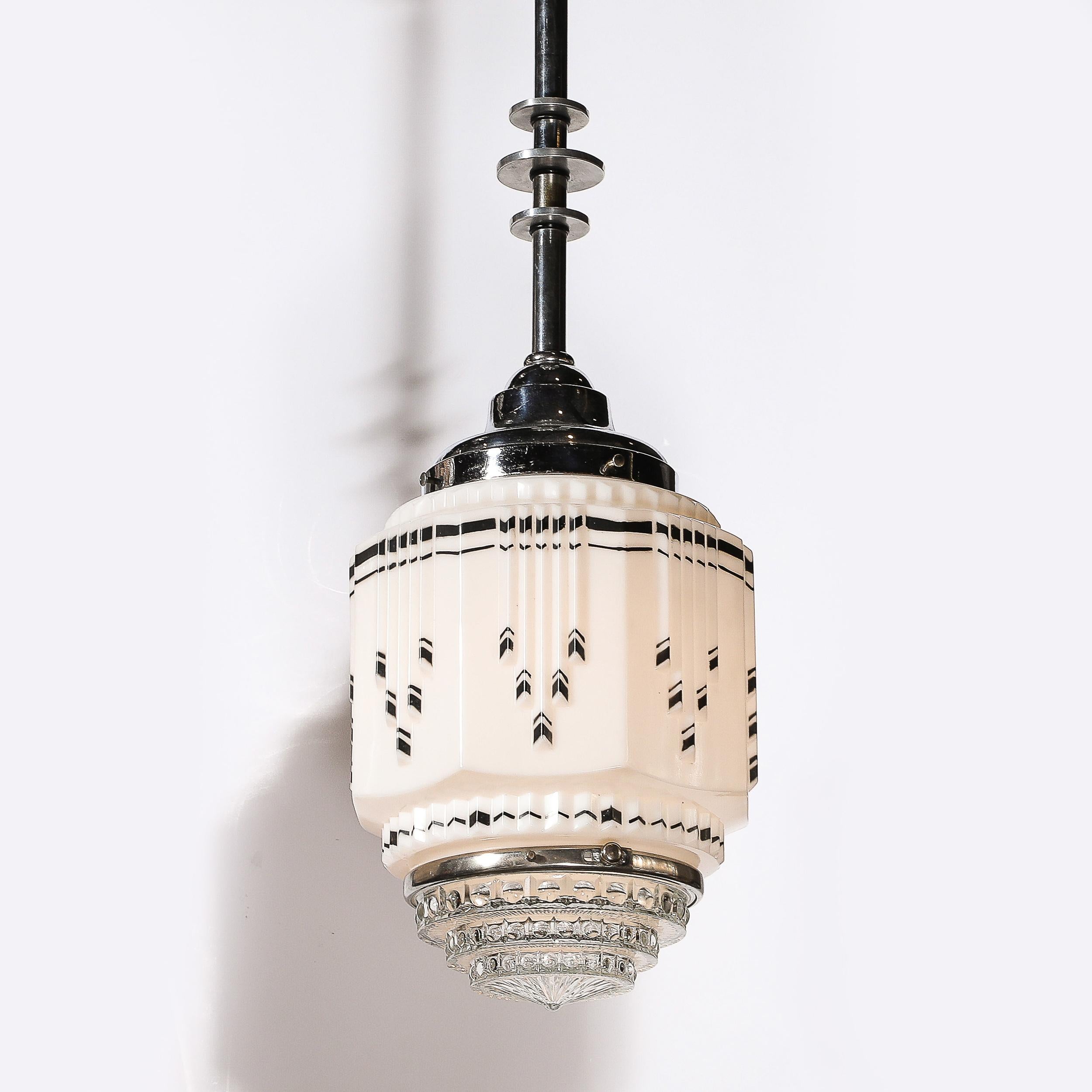 Dieser schöne und materiell exquisite Art Deco Skyscraper Style Milk Glass Chandelier mit schwarz emaillierten Details und verchromten Beschlägen stammt aus den Vereinigten Staaten, ca. 1935. Es zeigt eine zeitlose geometrische Komposition aus