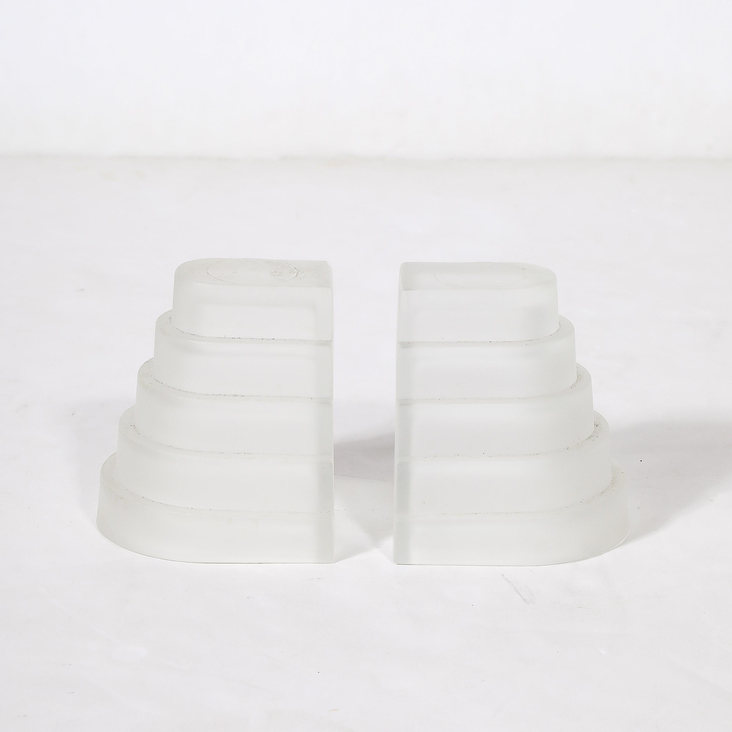 This lovely pair of Art Deco Skyscraper Style Molded and Frosted Glass Bookends originate from the United States, Circa 1935. Rendered in molded glass with a serene and beautifully achieved frosted finish, these bookends consist of five curved