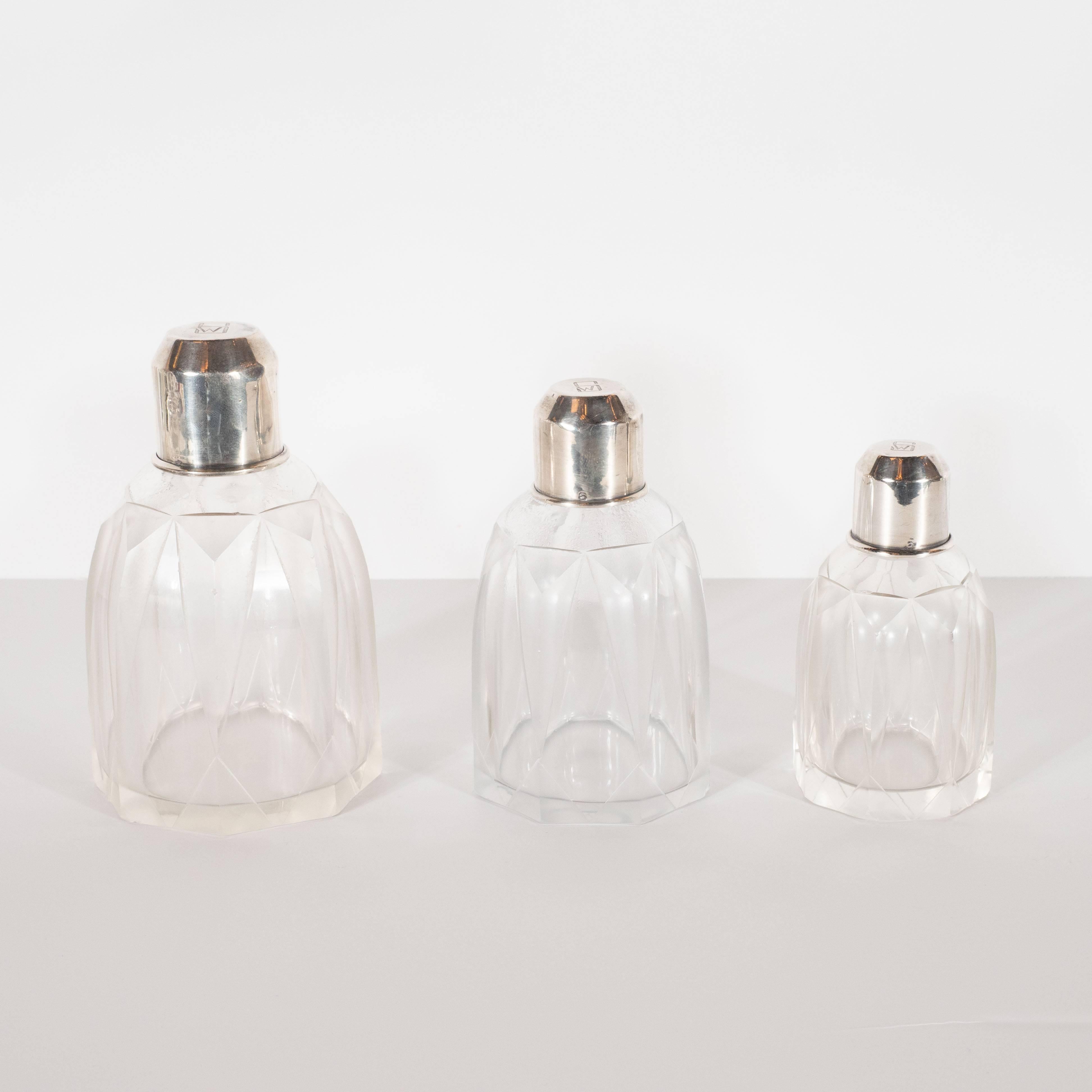 This elegant Machine Age Art Deco Perfume set was realized in France- where the finest silversmiths resided during this period- circa 1930. It features three octagonal vessels of varying sizes with triangular forms etched in relief; cylindrical