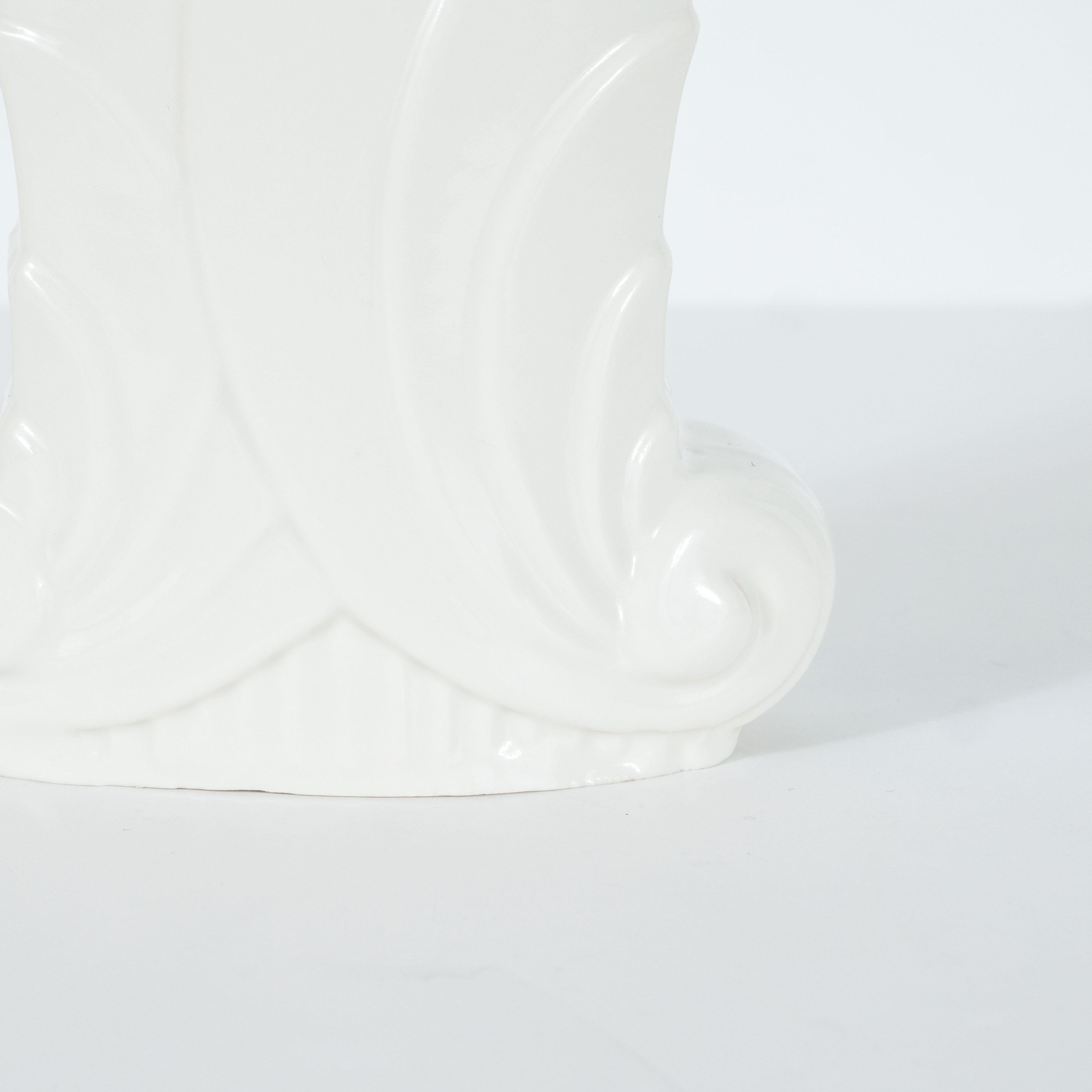 Ce vase Art déco raffiné a été réalisé aux États-Unis par le fabricant estimé Abingdon Co. vers 1940. Il présente une base cannelée et un corps rectangulaire étagé qui se superpose à des formes étagées de volutes stylisées et se termine par une