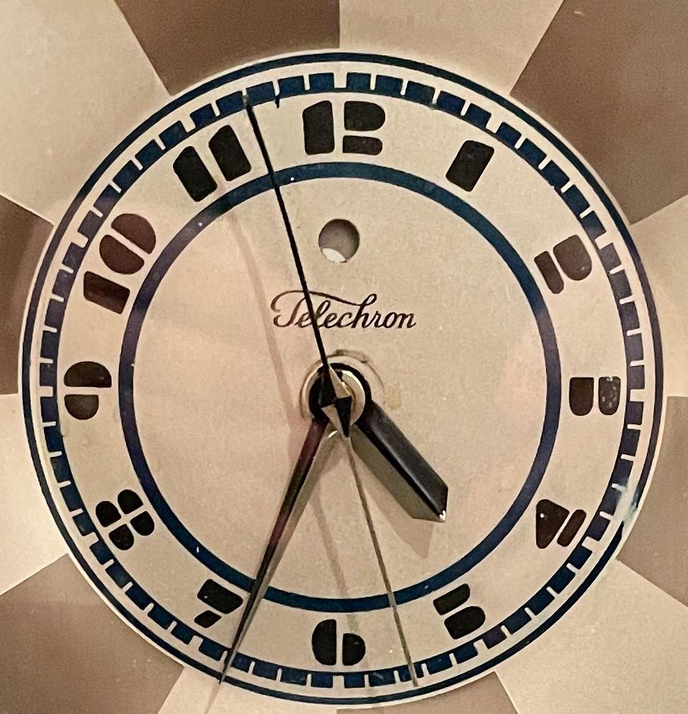 Art Deco skyscraper warren Telechron clock 431Modernique by Paul Frankl, 1928. It features Machine Age numbering around the dial, circumscribed by a starburst motif in alternating bands of silver and white gold hues. It is inscribed “Telechron” in