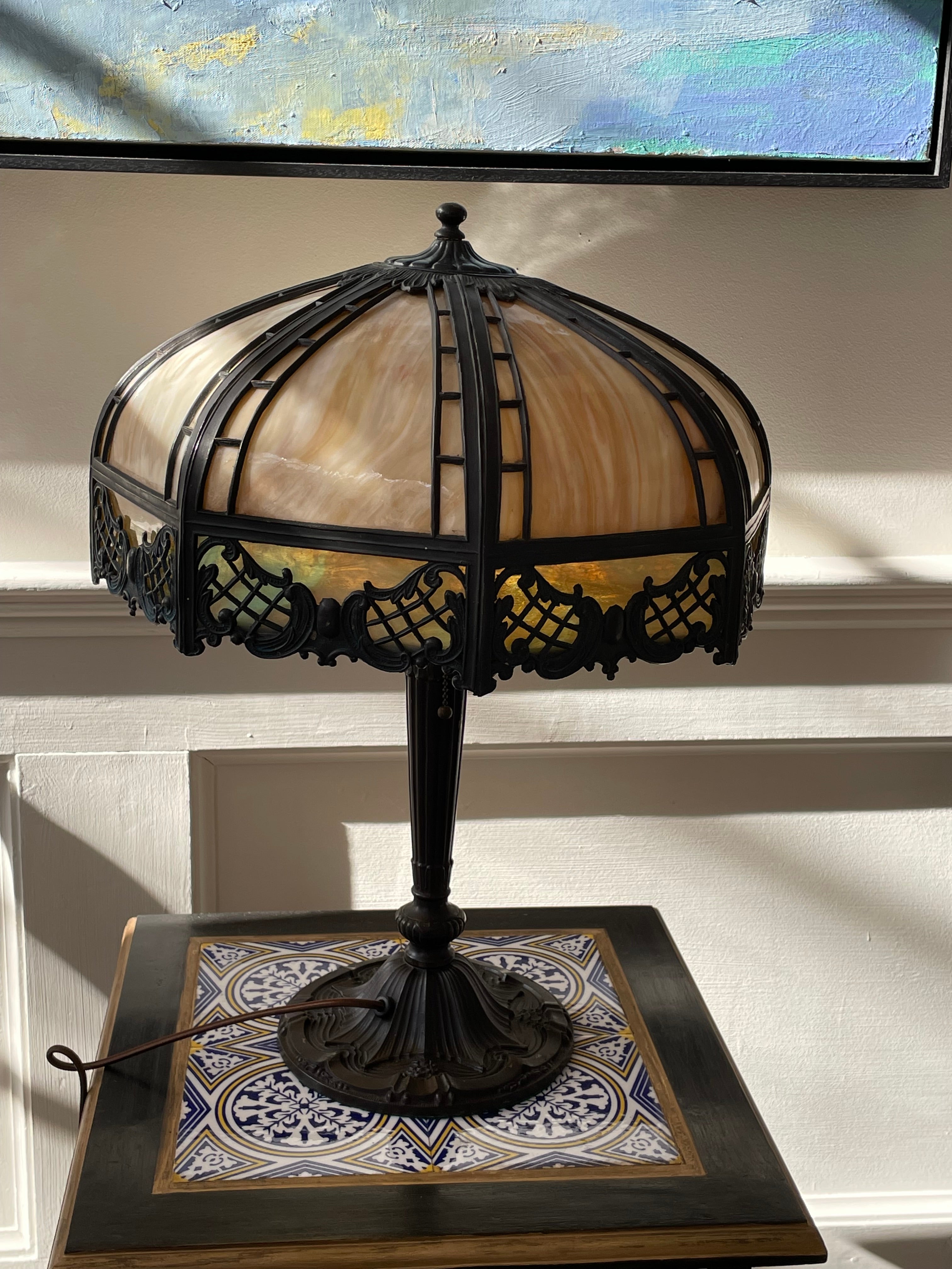 A rare and exquisite Art Deco table lamp from The Pittsburgh Lamp, Brass and Glass Company. Signed and documented as same. It is in excellent condition with no breaks in the slag glass panels. Once lit, there is wonderful fire to the glass. Embossed