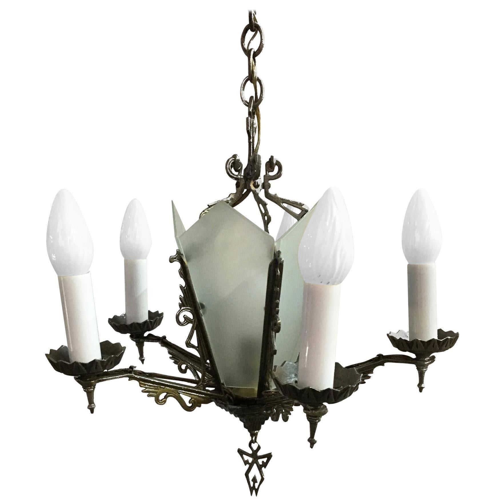 Five-arm geometric Art Deco chandelier with candle-style lights and a light-up slat glass center. The piece features scrolling details throughout while the base of the chandelier features a geometric pattern.

Dimensions: 20ʺH x 19ʺW × 19ʺD

United