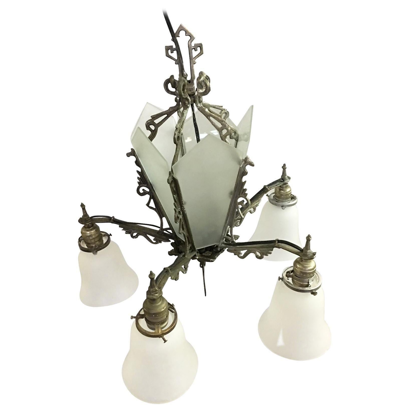 Lampadario Art Deco geometrico a cinque bracci con cinque luci a sospensione con paralumi a campana e centro in vetro opalino a lamelle illuminato. Il pezzo presenta dettagli a scorrimento mentre la base del lampadario presenta un motivo