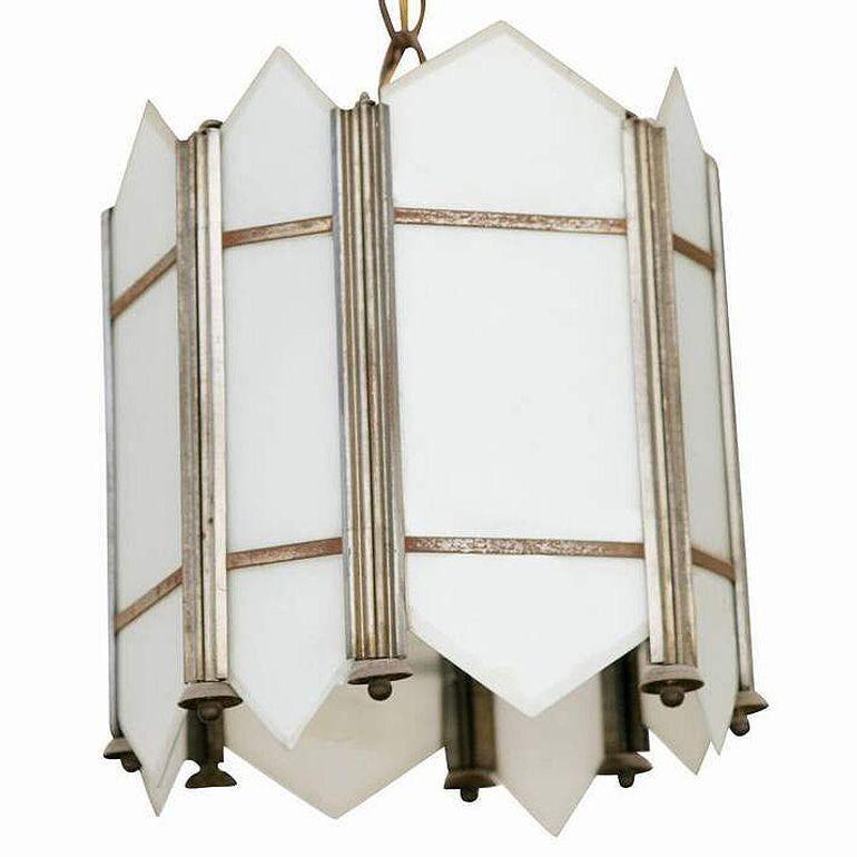 Realizzato nel 1920 circa, questo pendente da soffitto in stile Art Déco presenta un intricato disegno geometrico con inserti in vetro opalino bianco flash a lamelle.
