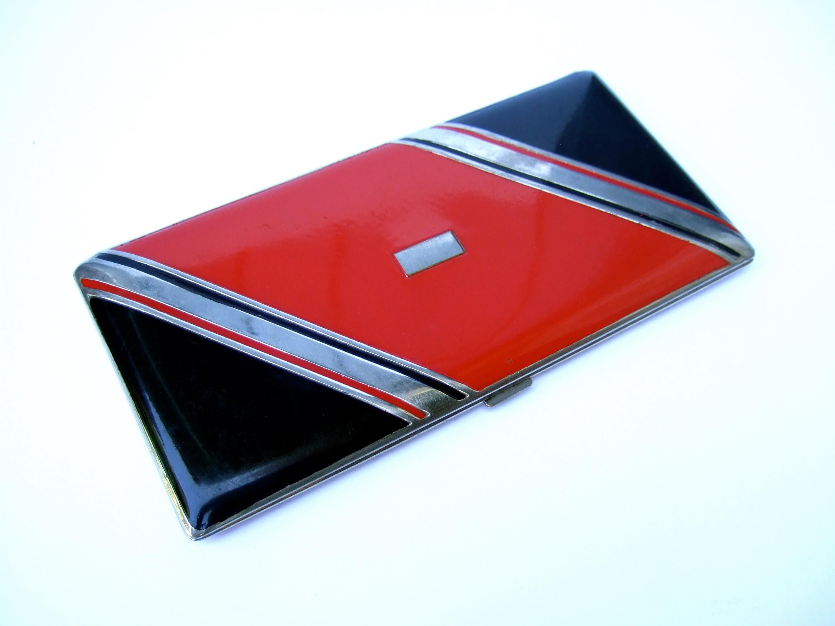 Art Deco sleek red & black enamel unisex cigarette case c 1940s
The elegant cigarette case is designed with a striped enamel
 lid cover with bold red & black geometric lacquered panels 

Accented with chrome metal linear bands across the lid