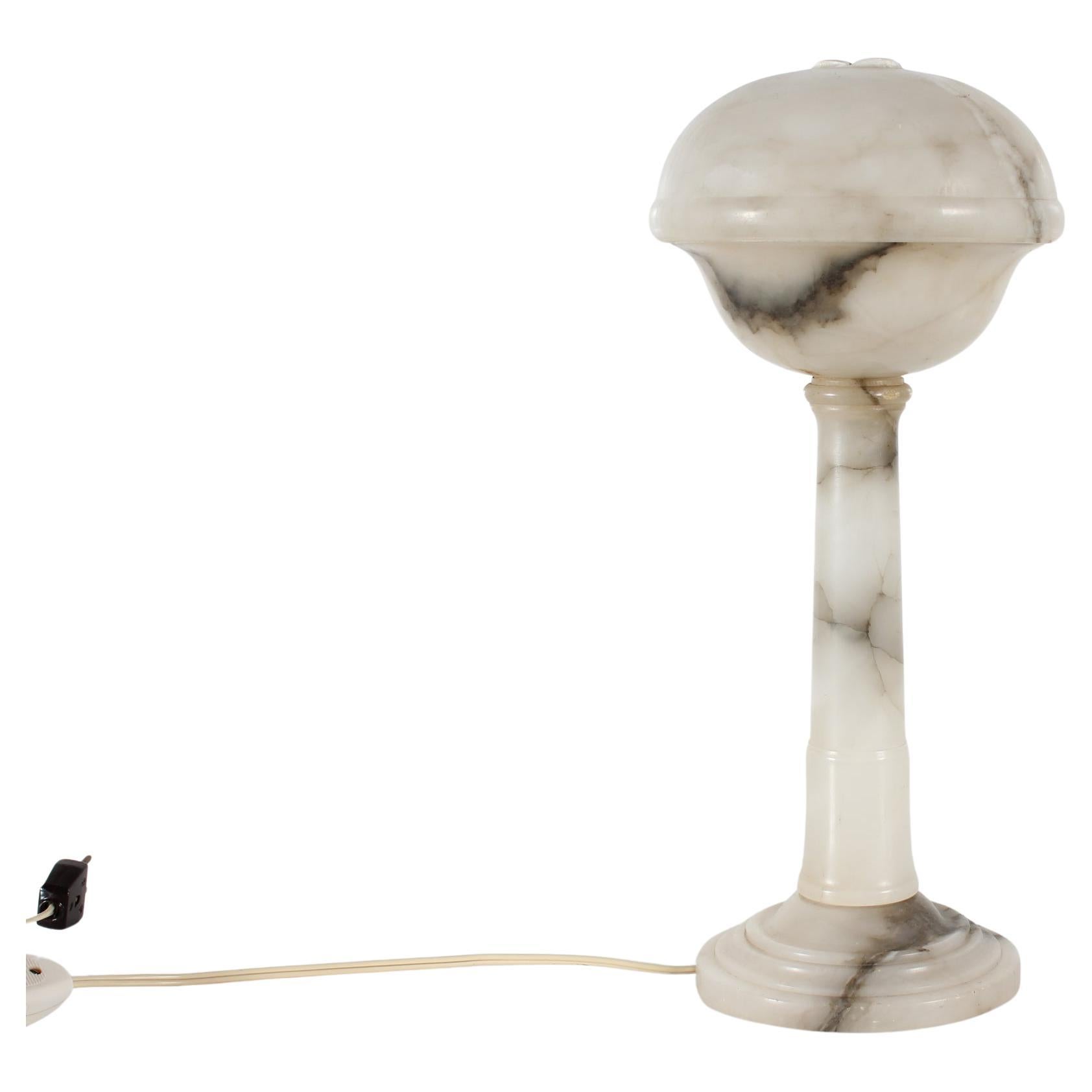 Art Deco alabaster table- and desk lamp. 

Alabaster is a light and relatively soft material that can be turned into all sorts of shapes.
It was often used for vases and lighting in the 1930s and 1940s as the light can be seen through and gives fine