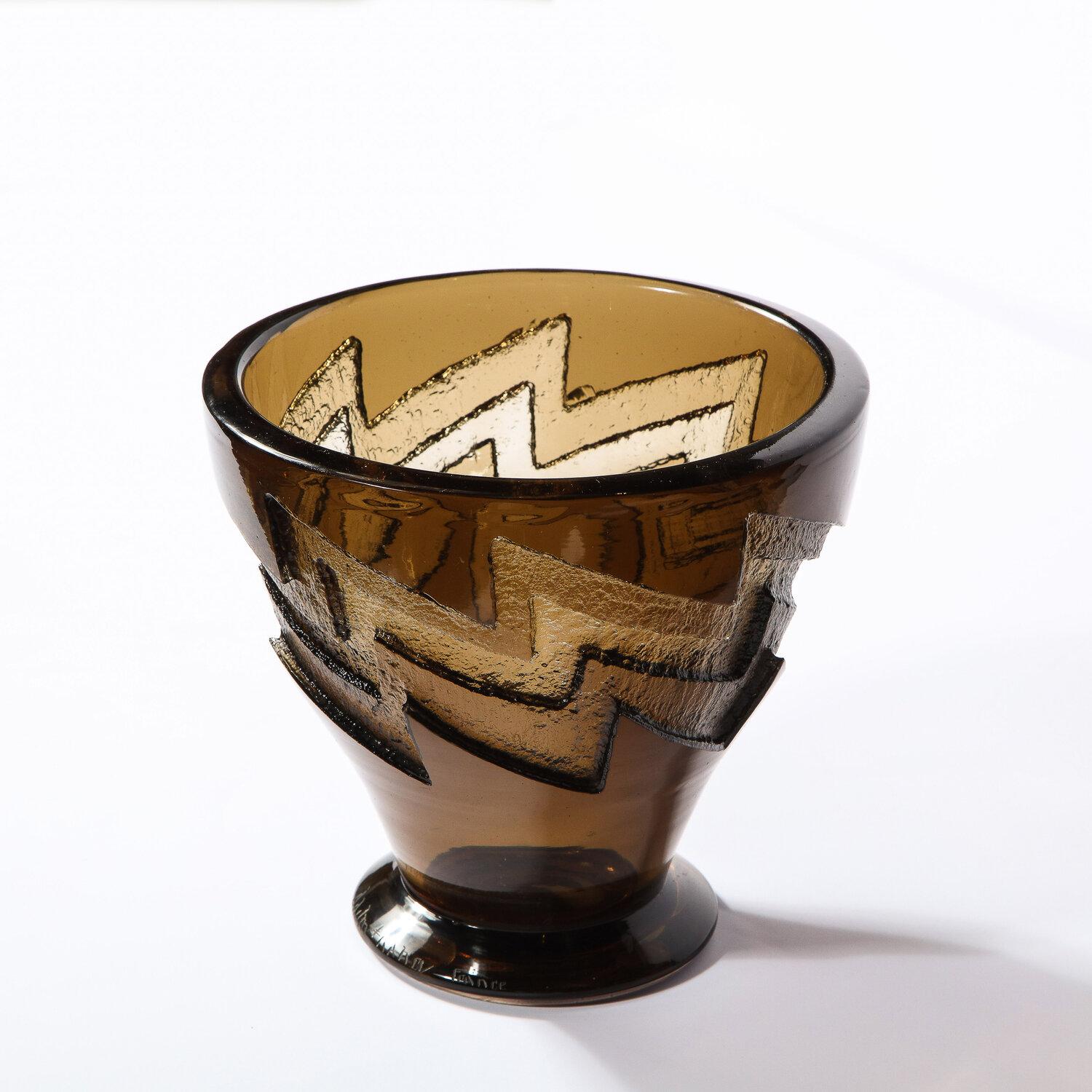 This refined Art Deco vase was realized and signed Daum Nancy in France, circa 1930. Handblown in textural molded glass, it offers a tapered conical body with a round cantilevered base and circular mouth in a rich smoked sable hue. A graphic and