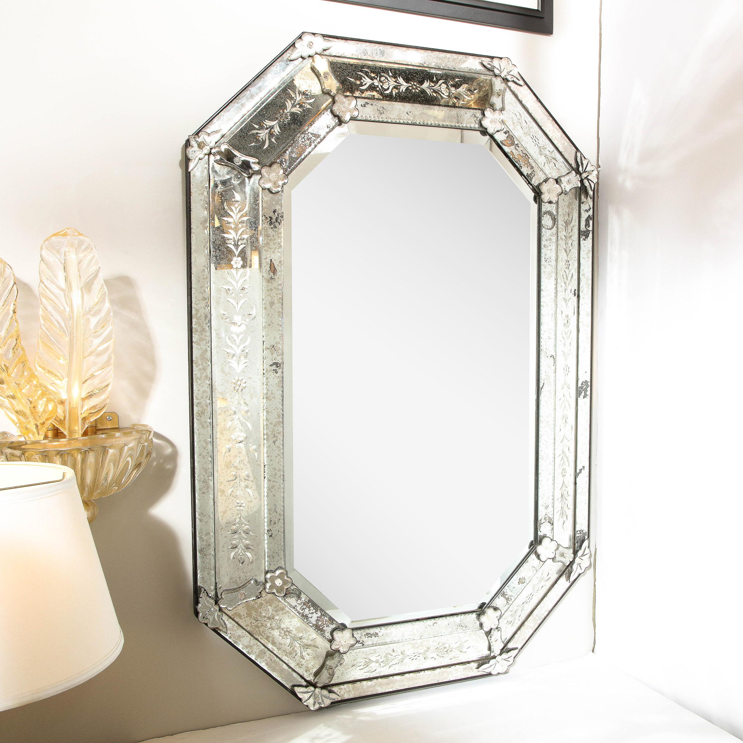 This stunning Art Deco octagonal Venetian mirror was realized in France circa 1935. The piece is composed of eight straight sides that intersect at angles forming the perimeter in raised smoked and antiqued mirror. The frame is composed of three