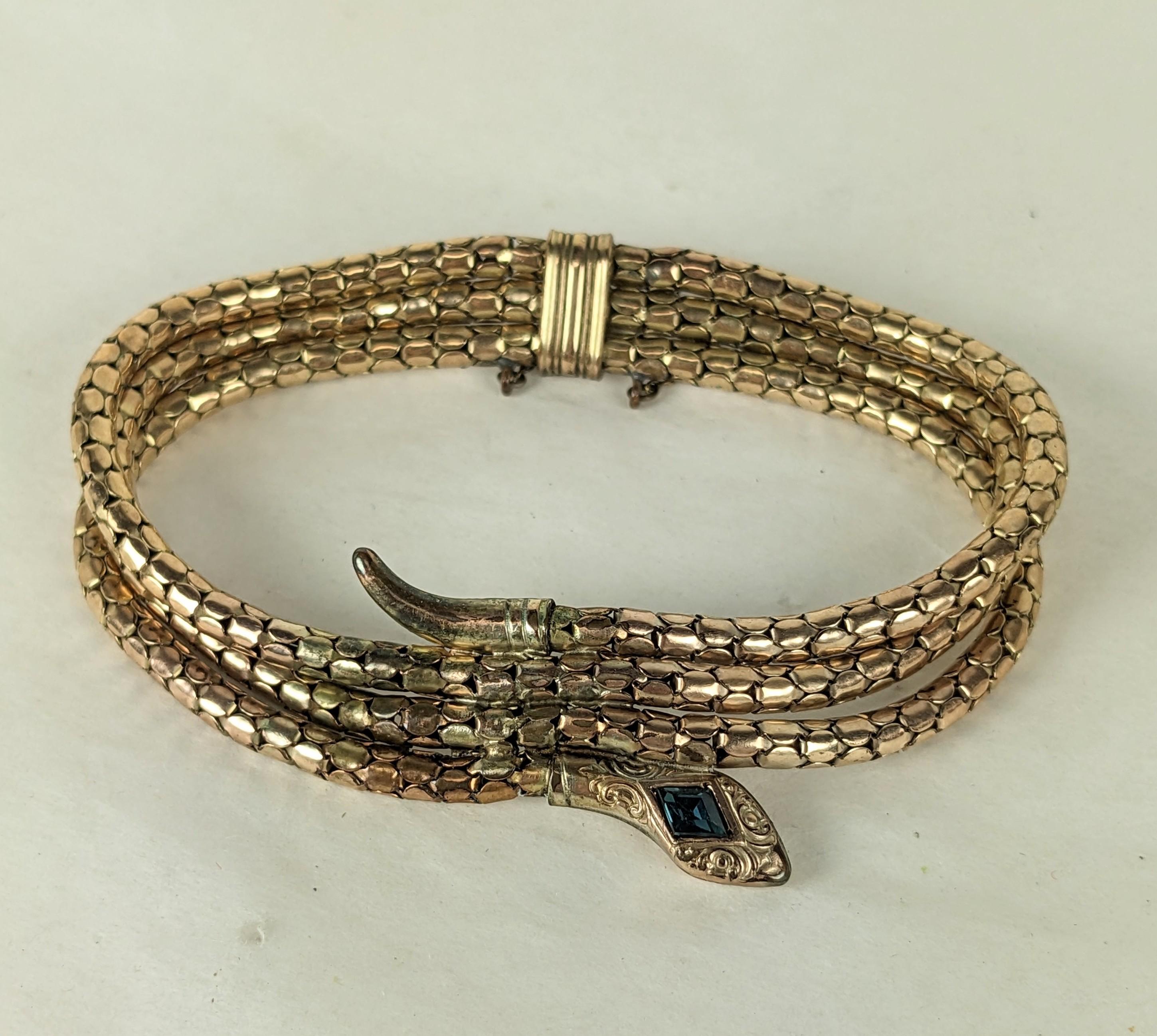 Bracelet Art Déco serpent en or composé d'une triple chaîne serpent avec la tête et la queue accentuées sur le devant. Maillon souple avec tête en pâte de saphir. Européen des années 1930. 7.25