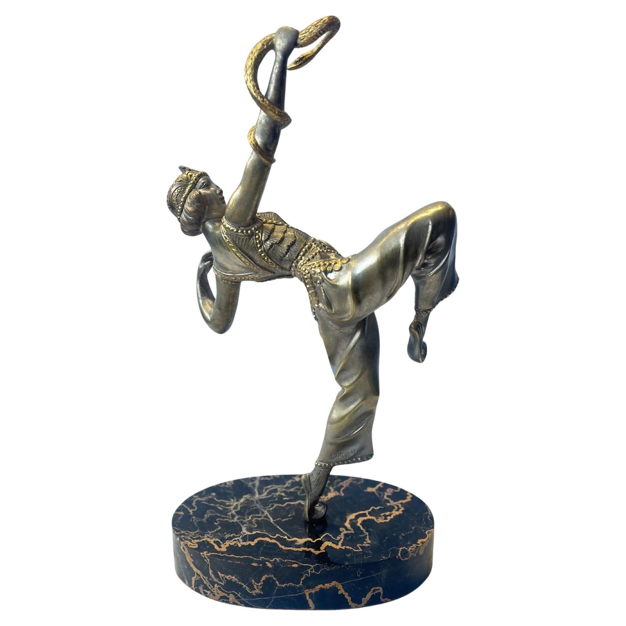 French Art Deco patinated bronze sculpture of a snake charmer orientalist dancer holding an alluring pose, while having a snake wrapped around her arm. It is standing on an oval black veined marble base. Made by Samuel Lipchytz in c.