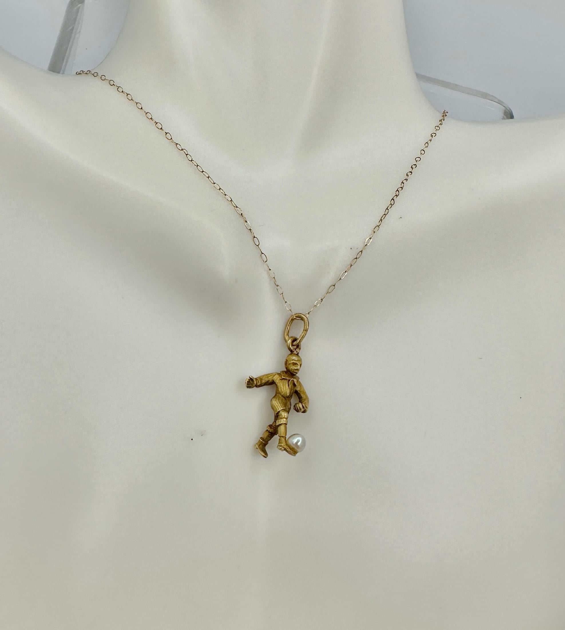 THIS IS A WONDERFUL ANTIQUE ART DECO PENDANT OR CHARM IN THE FORM OF A SOCCER FOOTBALL PLAYER KICKING HIS PEARL BALL WITH WONDERFUL DETAILS IN THE FACE AND UNIFORM AND IN 10 KARAT GOLD - A SPECIAL PIECE DATING TO CIRCA 1920.
The soccer football