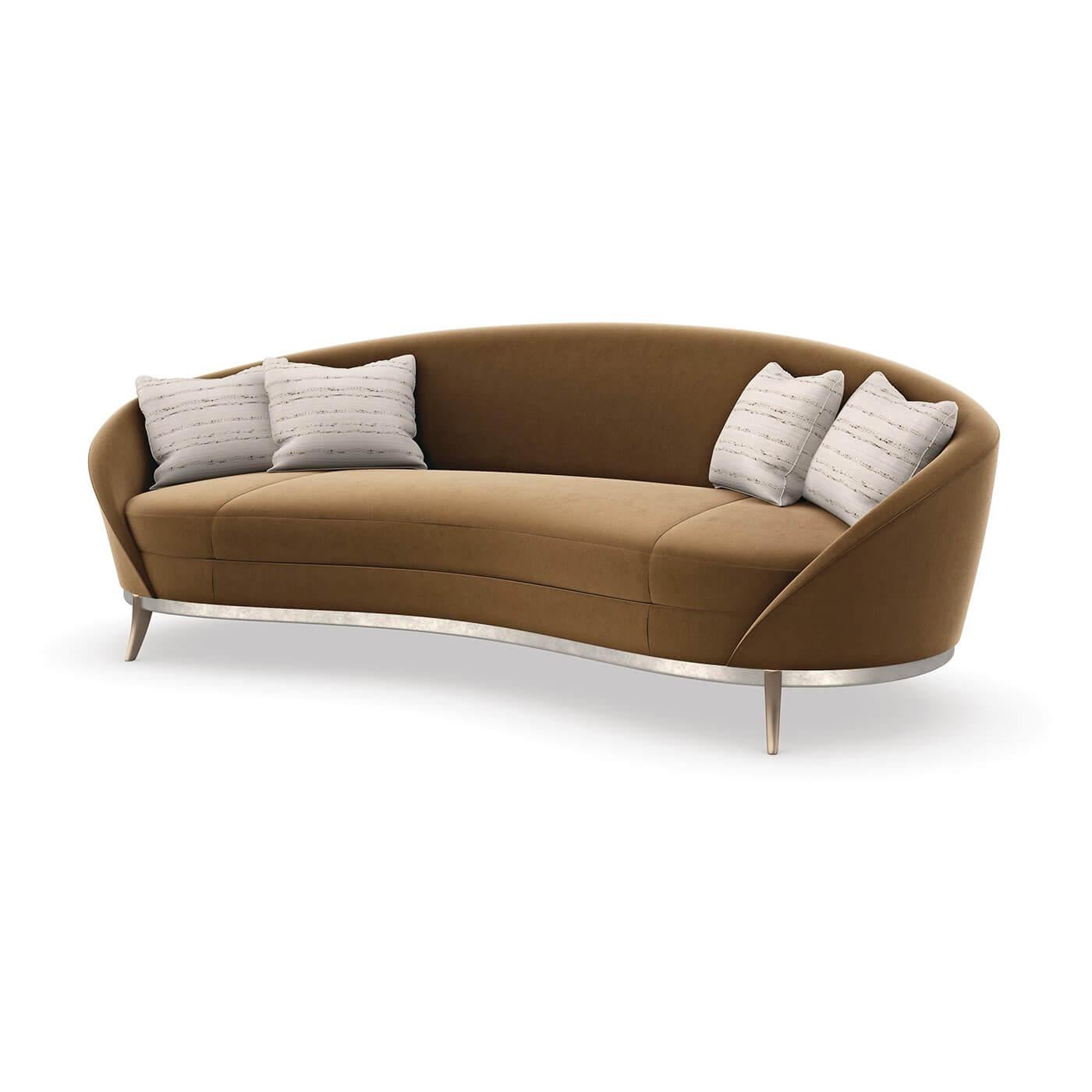 An Elegant Art Deco Kidney Sofa. With an iconic kidney shape, this sumptuous sofa offers enveloping comfort in a warm caramel-colored velvet.

Its gracefully flowing form features a smooth back and bowed bench seat, with French seams for a