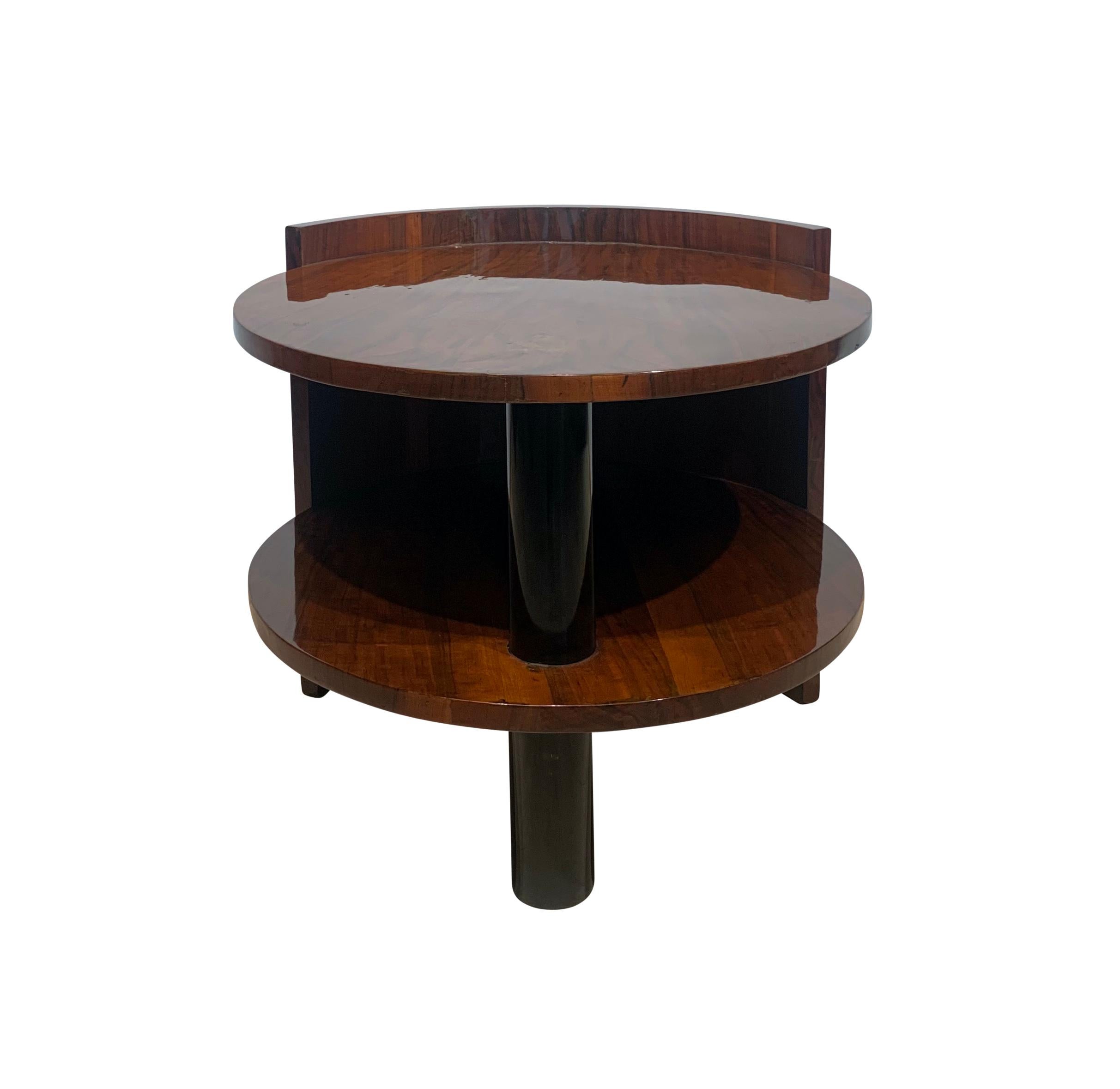 Large, round Art Deco sofa or coffee table from France around 1930.
* Elegant design
* Walnut veneered on softwood
* Restored and hand polished shellac
* Ebonized columns 
* Top with black glass plate
Dimensions: 
* H 65/60 cm, Ø 75 cm
* H 25.6“ /