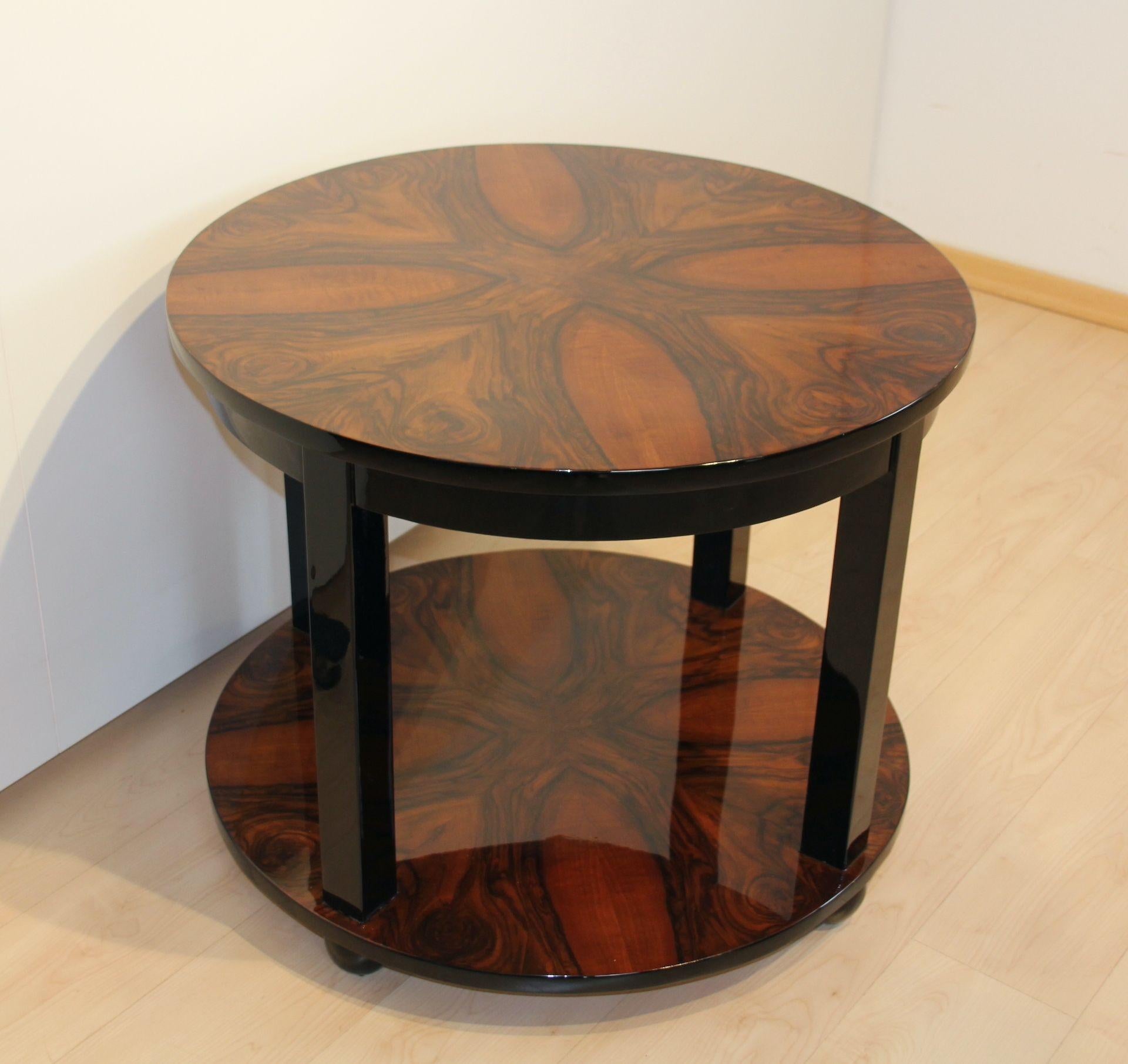 Large, round Art Deco side, sofa or coffee table from France about 1930.
 
Walnut veneered and high gloss lacquered. Black lacquered edges, feet and intermediate bars.
 
Dimensions: H 65.5 cm x Ø 80 cm.