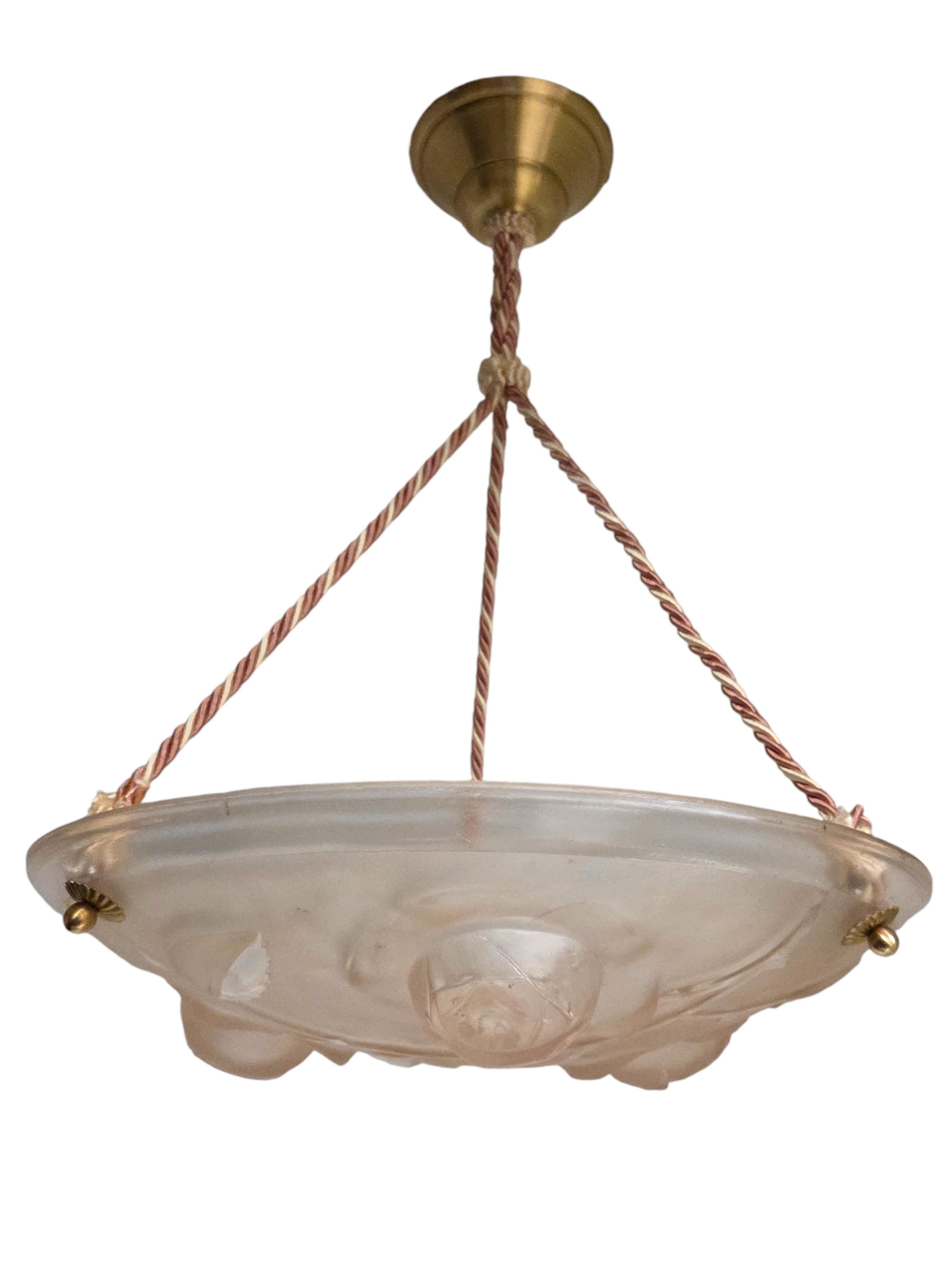 Cette coupe suspendue française originale est un charmant exemple de l'éclairage Art déco du début et du milieu du XXe siècle. 
Le bol en verre rose tendre est orné de motifs floraux et feuillus délicatement moulés, ce qui lui confère un éclat