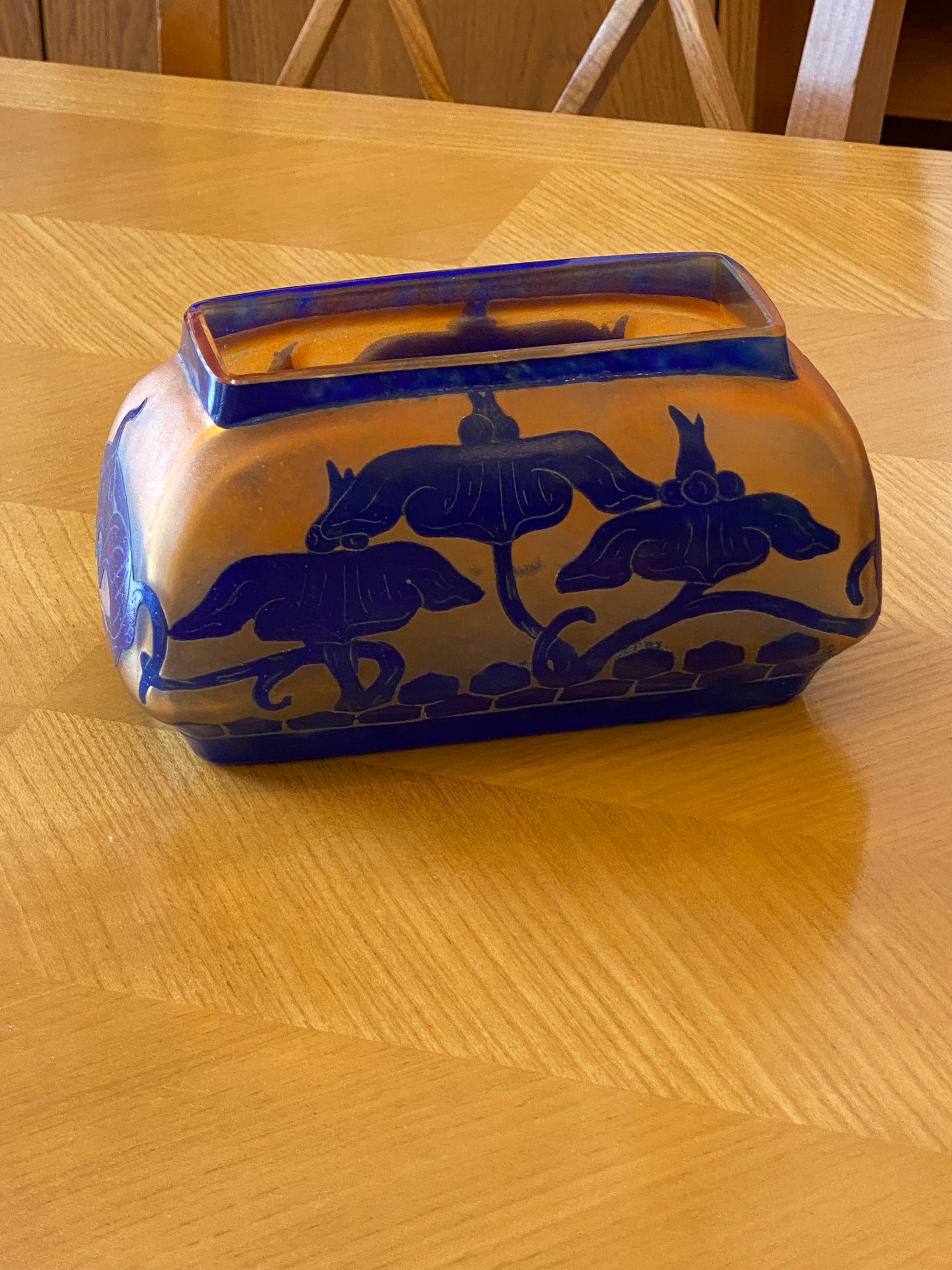 A rectangular shaped vase with Orange Opaline background overlaid with Cobalt Blue.  The floral pattern is in Cobalt Blue and acid-etched.  This piece belong to the Solanée serie of Le Verre Français.

Charles Schneider was a renowned glassmaker