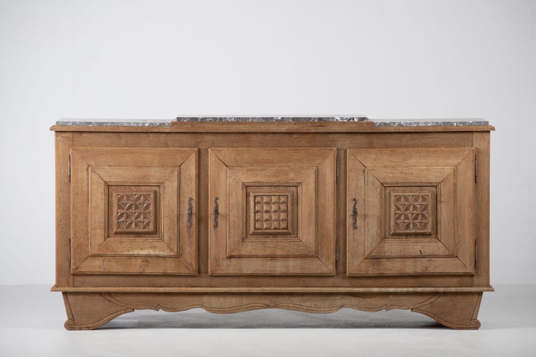 Very elegant Credenza in solid oak, France, 1940s.
Large Art Deco Brutalist sideboard. 
The credenza consists of three storage facilities covered with very detailed designed doors. 
Very elegant 
The refined wooden structures on the doors create a