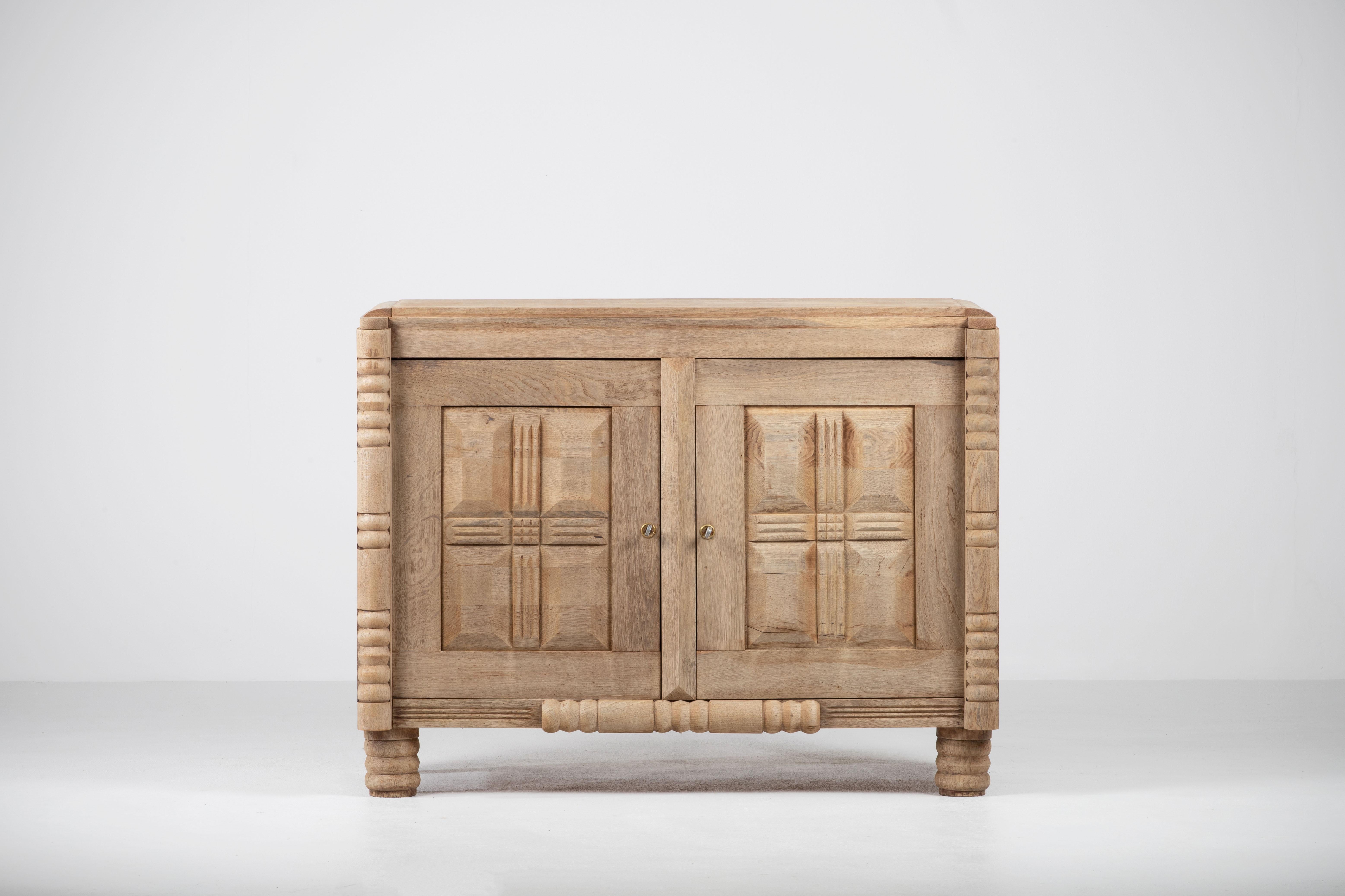 Credenza, solid oak, France, 1940s, after Charles Dudouyt.
The credenza consists of two storage facilities and covered with very detailed designed doors.
We offer this piece in a bleached finish.