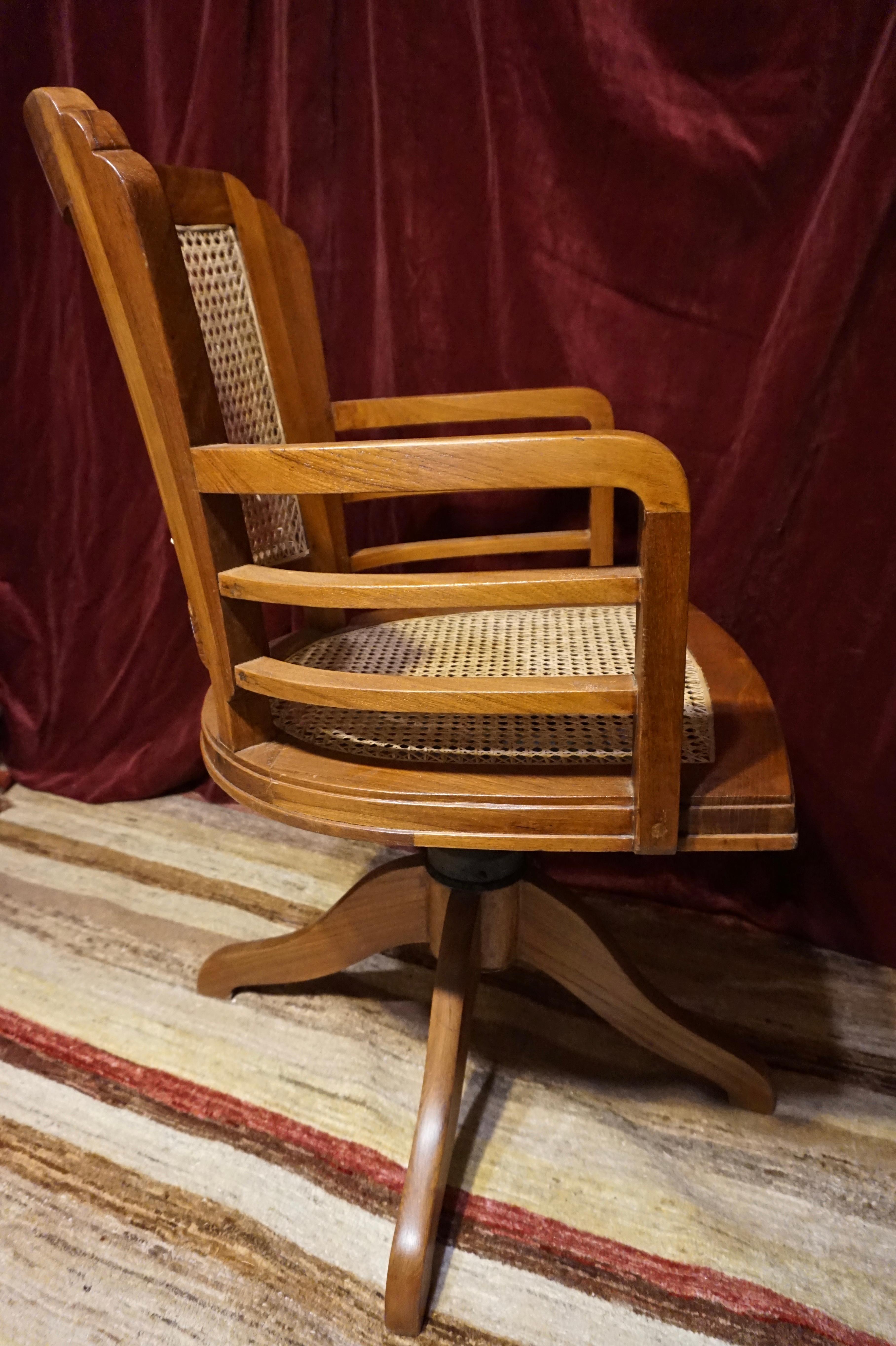 Art Deco Teak revolving chair with arms and original mechanism. Beautifully handcrafted from solid wood. Clean lines and sturdy throughout. Re-caned to last another lifetime. The cane work has been woven through the wood for durability. Very
