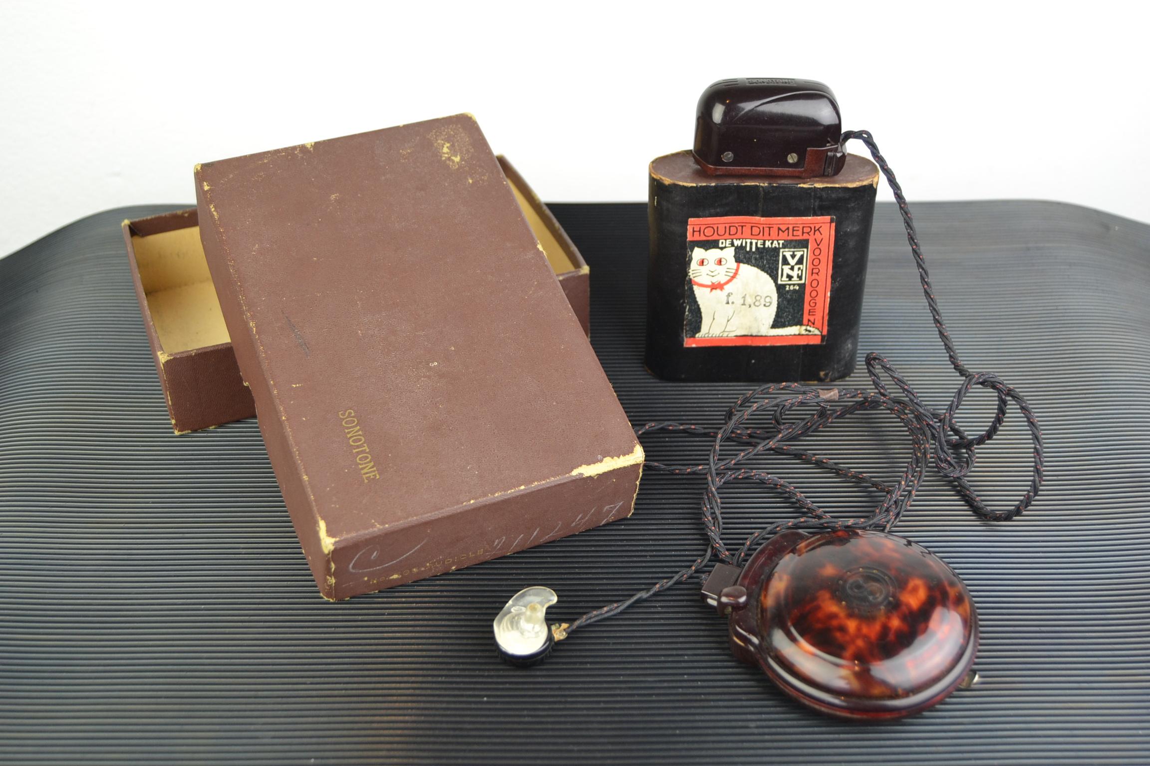 Art Deco bakelite - tortoise celluloid look hearing aid by Sonotone, USA.
This antique medical devise dates circa 1920-1930, comes with his original cardboard Sonotone packing box and with a beautiful old Dutch battery of de Witte Kat - White Cat.