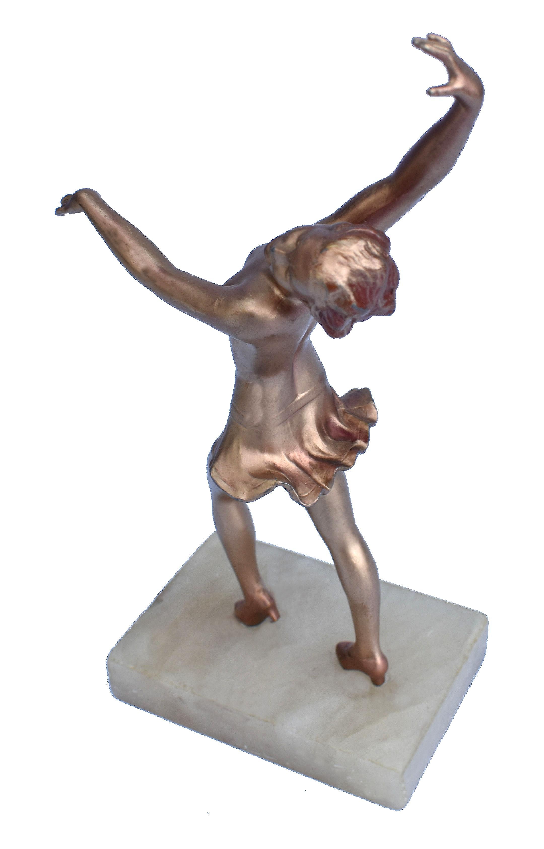 Nice original example of Art Deco era patinated/painted spelter figurine of a semi-nude dancing girl. Slim gold-painted girl with wearing headdress and pink undershorts; very attractive, lively and innocent dancing pose. Two-part black veined marble