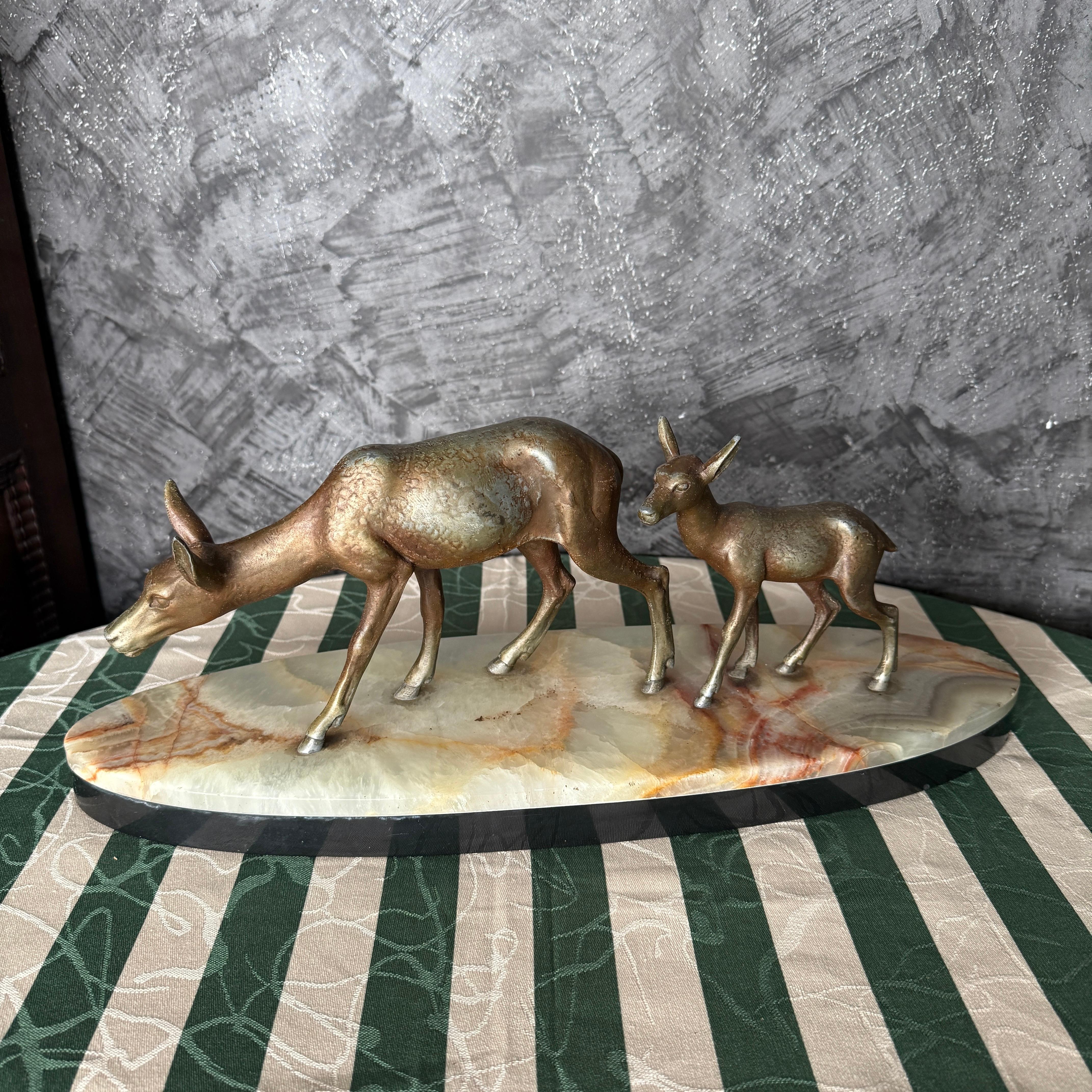 Cette étonnante sculpture Art déco représente un gracieux chevreuil et son délicat faon, magnifiquement moulés en fonte et finis dans une patine chaude, semblable à celle du bronze. Le couple respire l'élégance et l'équilibre naturel, capturant le